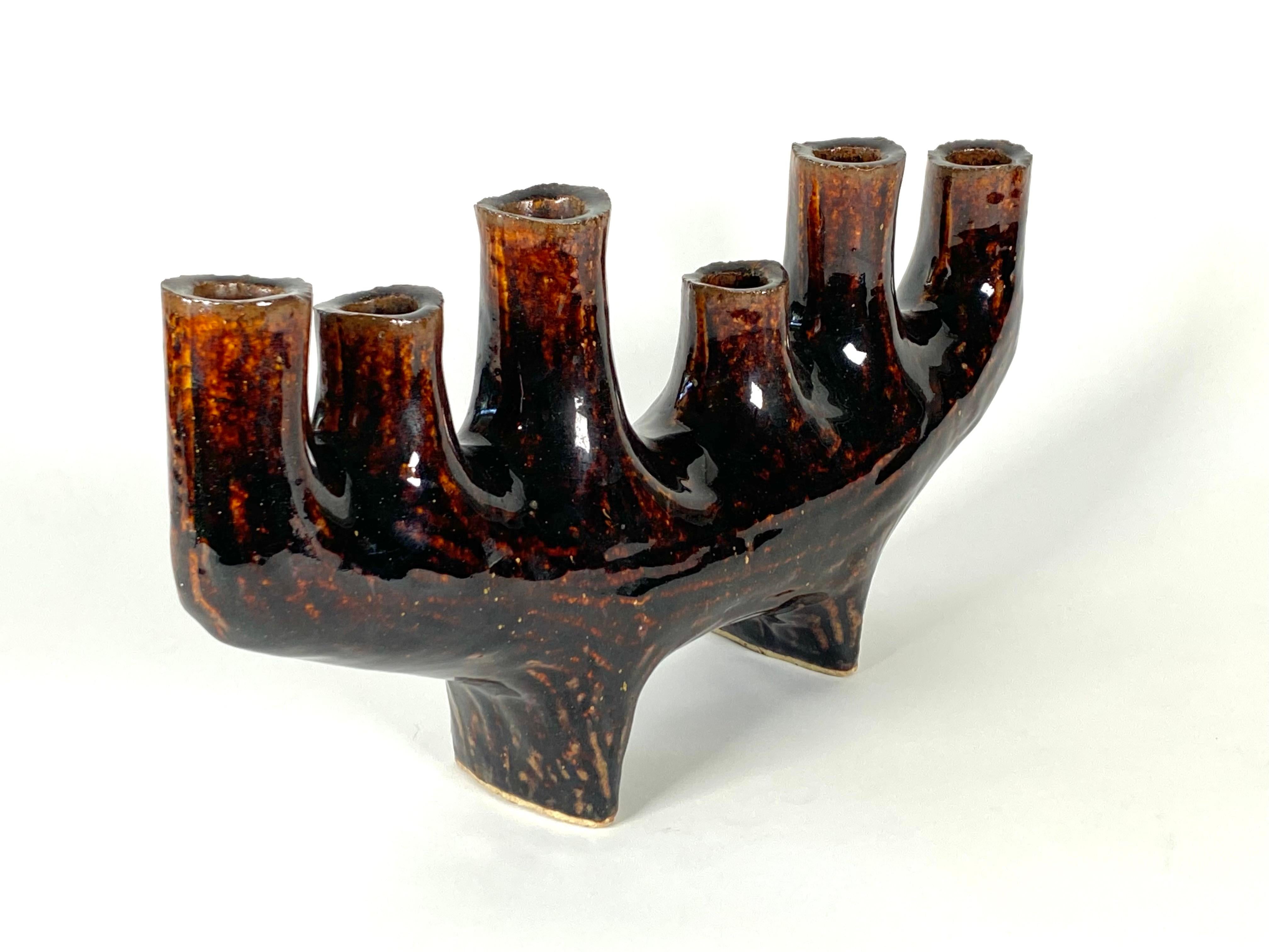 1960s abstract modernist footed ikebana vase in rich browns with a curved upward at the ends form. Having six graduating in height cylindrical columns, an unusual form. Markers mark on the bottom of one foot.
