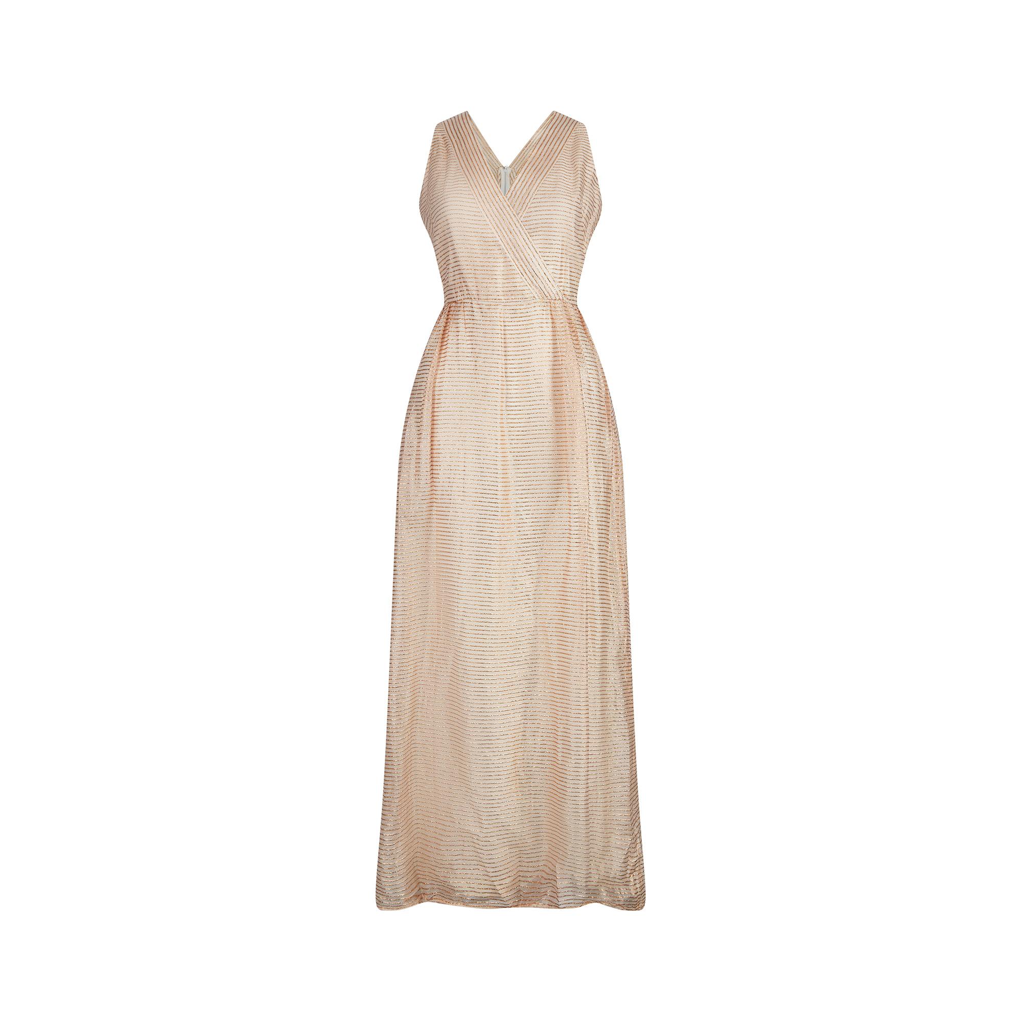 This 1960s cream and gold lurex maxi dress by Jean Allen could easily be dressed up for a formal event or worn more informally as resort wear. It is sleeveless and features a V neck crossover front, connecting at the waistband to create a flattering