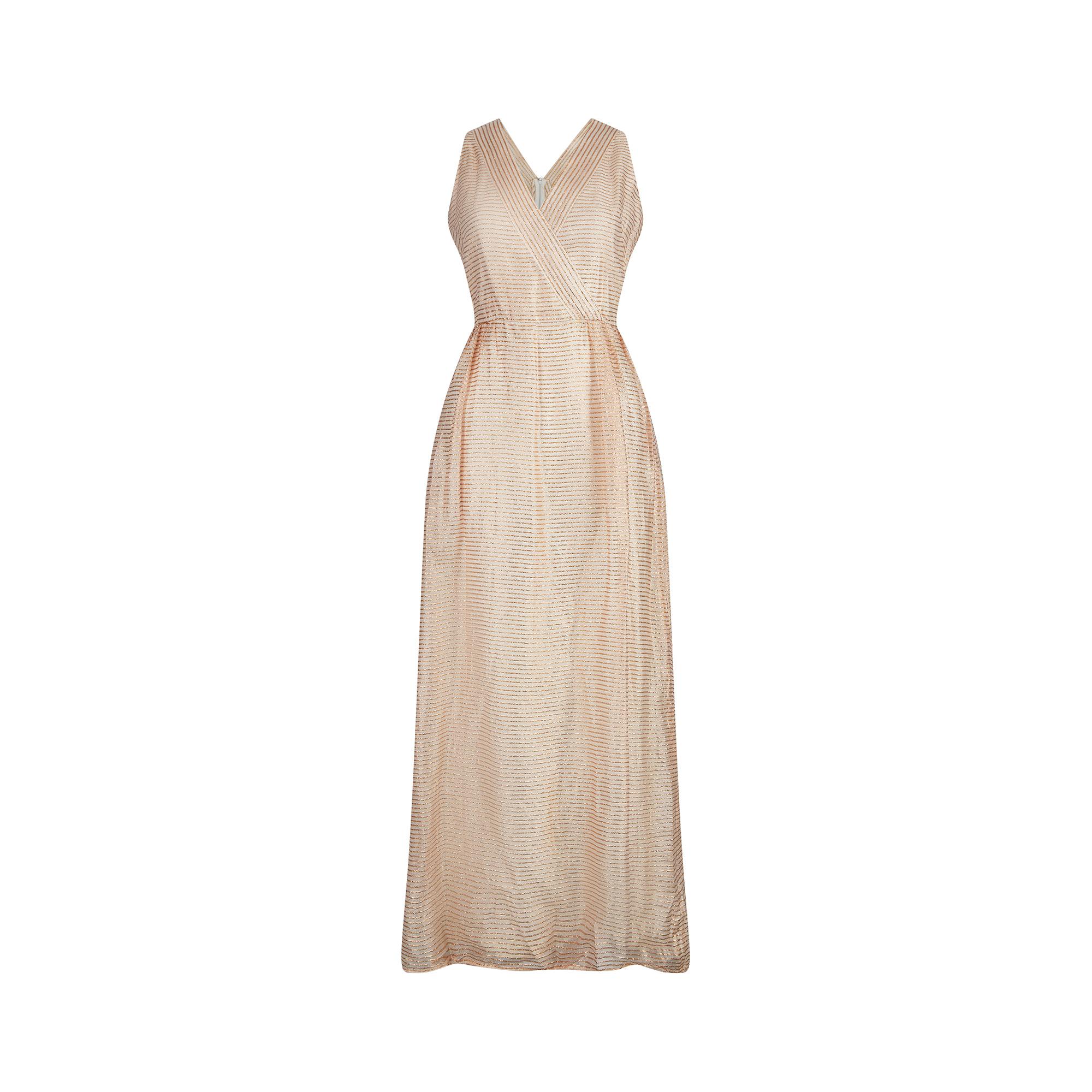 This 1960s cream and gold lurex maxi dress by Jean Allen could easily be dressed up for a formal event or worn more informally as resort wear. It is sleeveless and features a V neck crossover front, connecting at the waistband to create a flattering