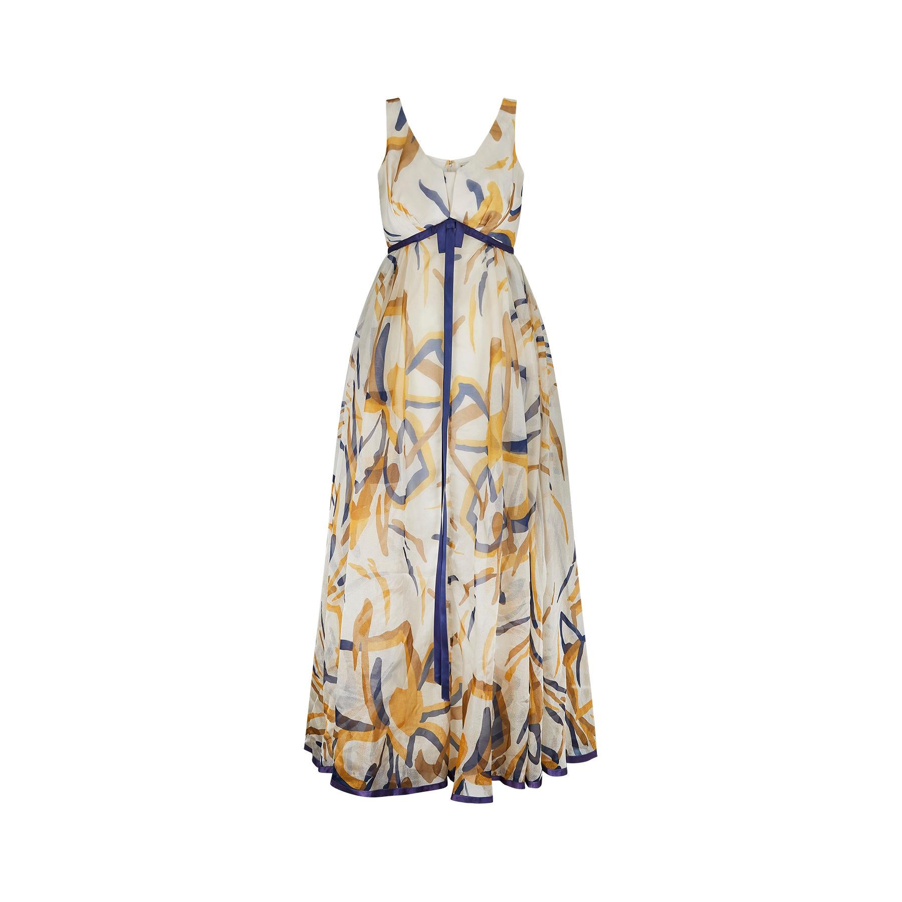 We love the colour combination on this 1960s Jean Allen maxi dress.  The print mixes warm golden highlights together with navy blue accents on cream in a painterly, abstract pattern. The dress has an inverted empire line and scoop neck from which