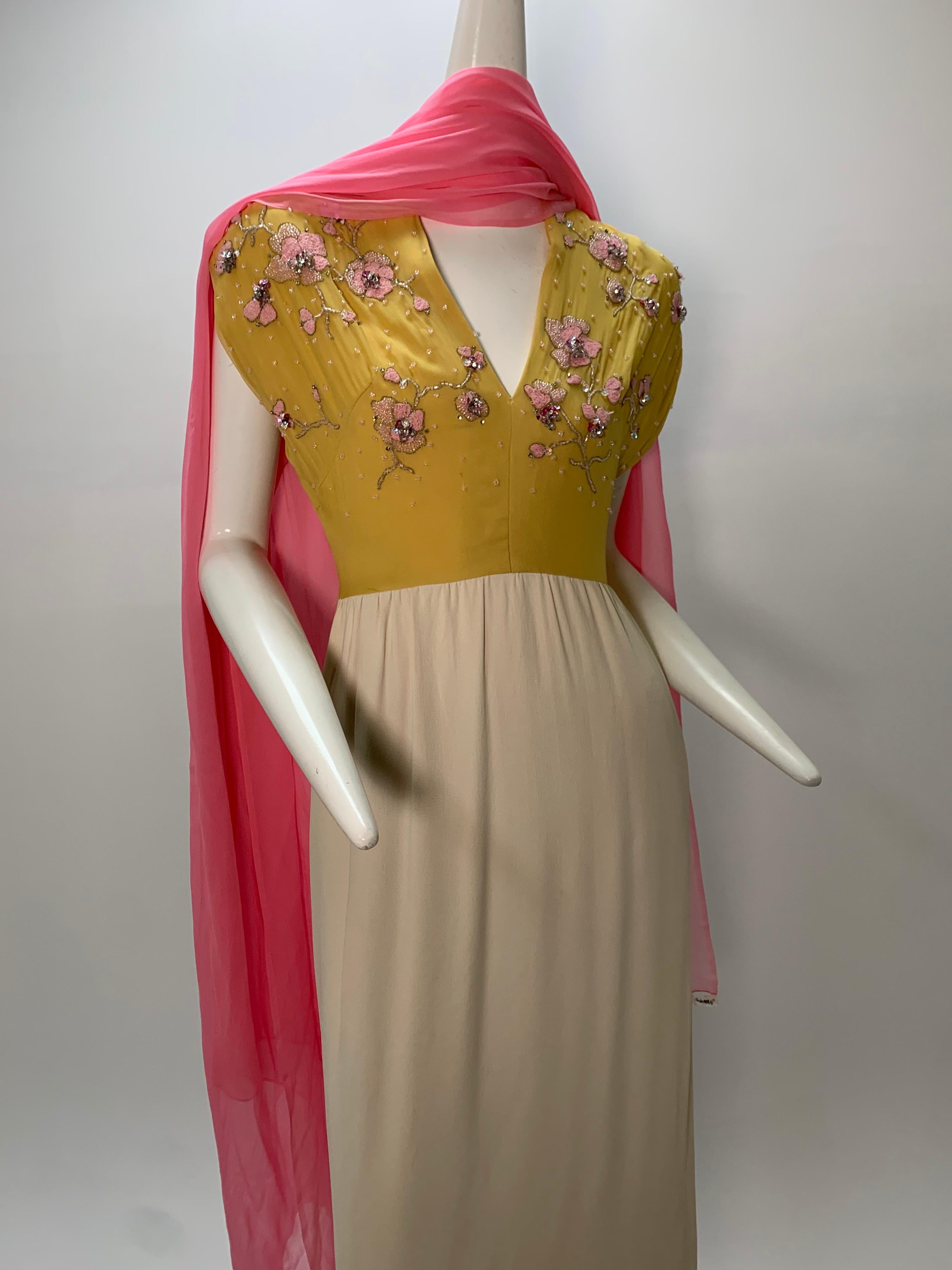 A 1960s John Hogan silk chiffon and crepe dress with drop-shoulder and a 1940s vibe: Silk chiffon mustard-color bodice embroidered in pink floral motif. Cream crepe skirt is cut long, at mid-calf. Pink chiffon accent scarf is included. 
