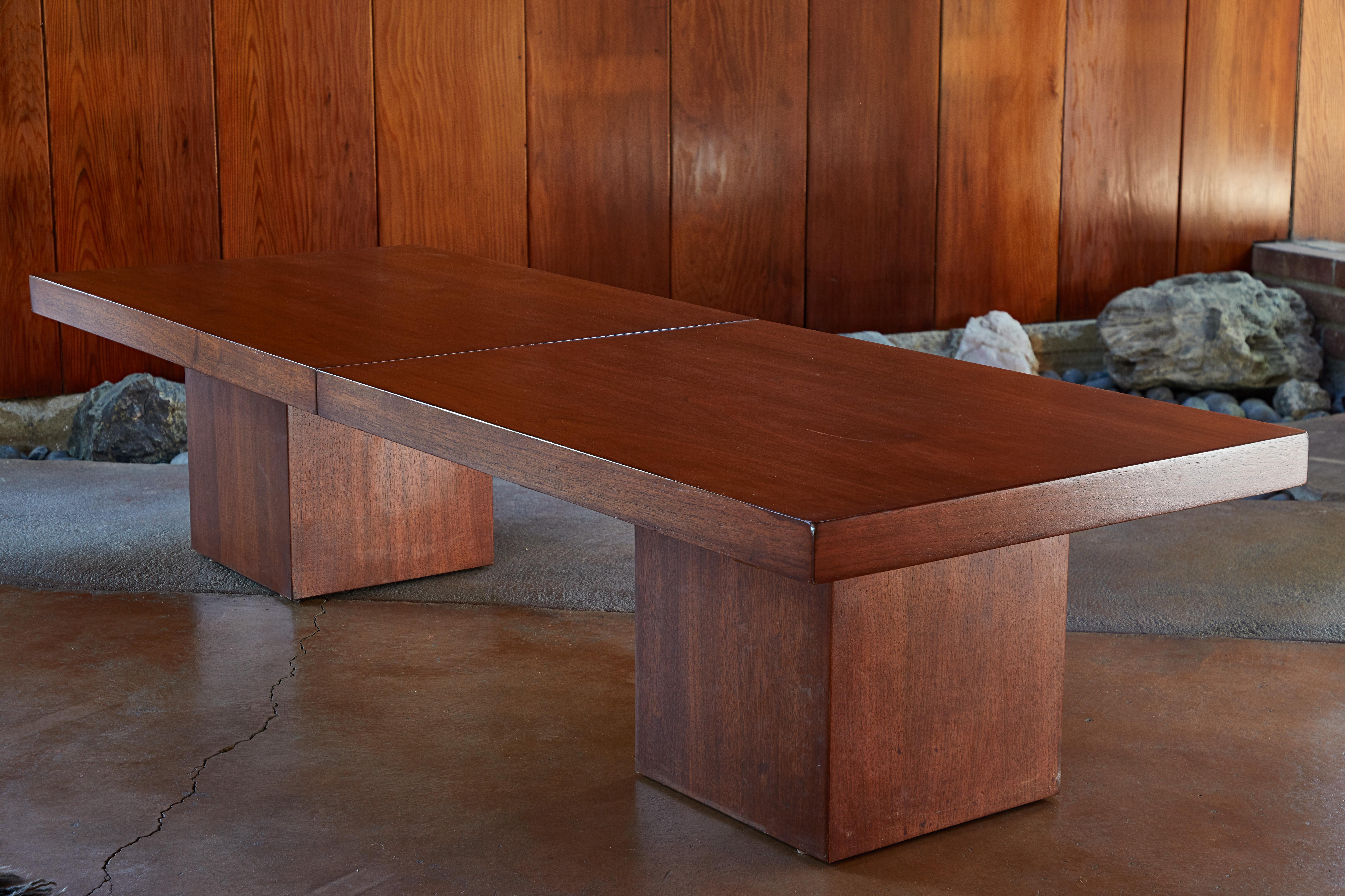 1960s John Keal expanding walnut coffee table by Brown Saltman. Executed in American walnut and black formica. The rectilinear top sits atop a pair of square bases, expanding approximately 80