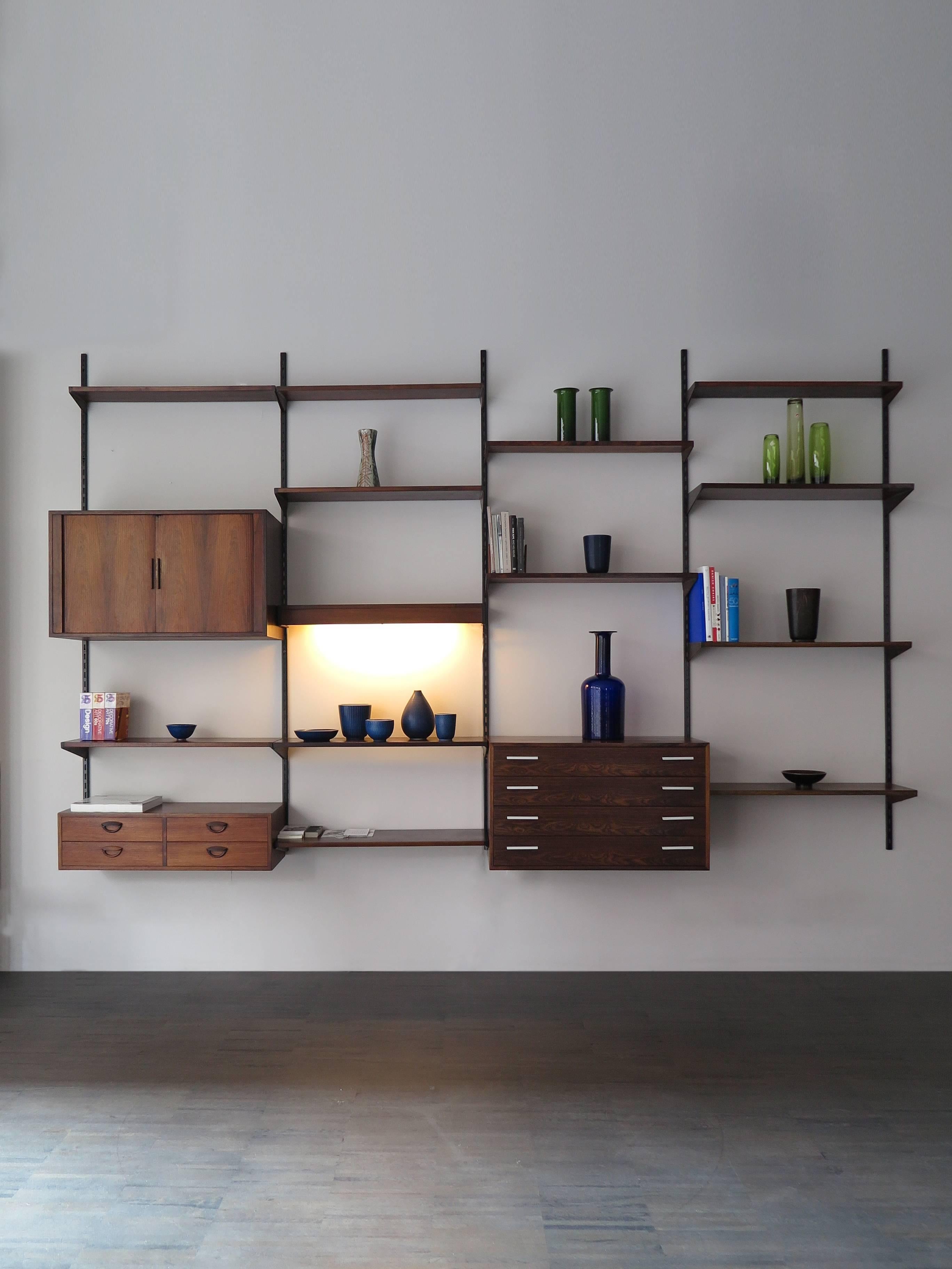 1960s, Danish, Scandinavian and Mid-Century Modern rosewood wall system designed by Kai Kristiansen for FM Mobler, wall system consisting of two chest, one cabinet with sliding doors, 12 shelves with different sizes depth and one shelf with light.