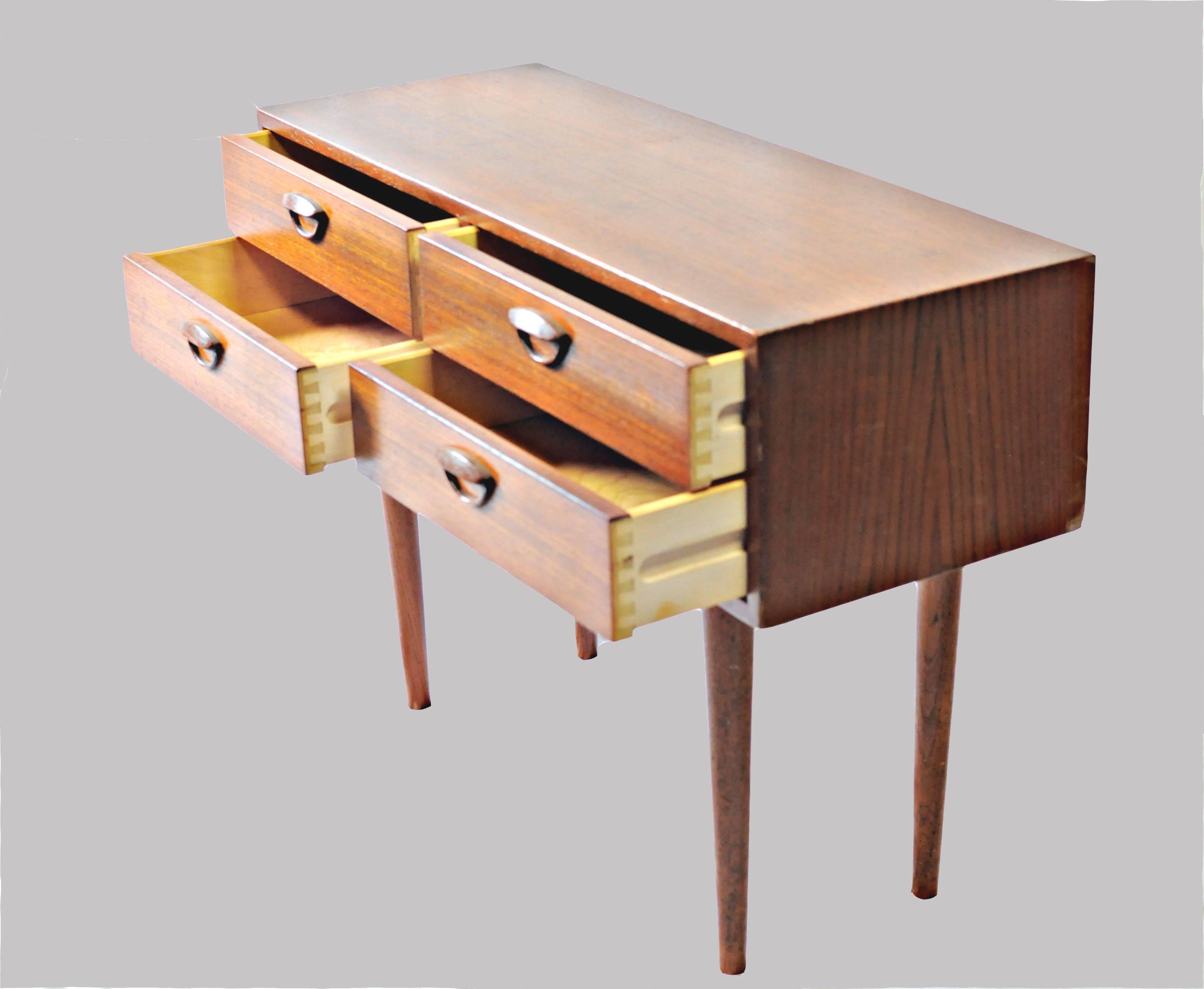 Small Danish teak dresser or console with four small drawers designed by Kai Kristiansen for Feldballe Møbelfabrik in the late 1950s.

The dresser / console features Kai Kristiansens classic eyelid design on each drawer pull and it´s seize and