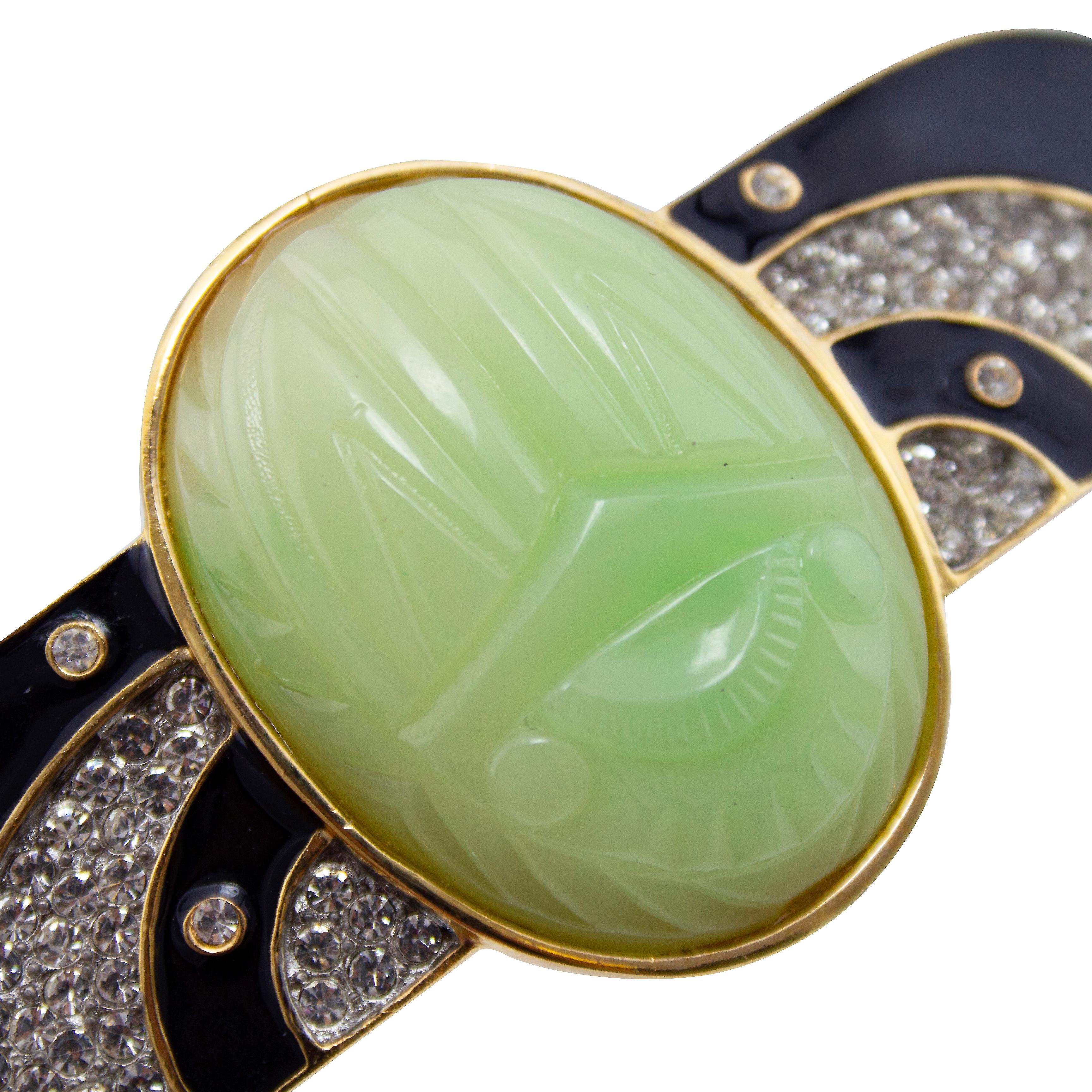 Unique and beautiful Kenneth Jay Lane winged scarab style brooch dating from the 1960s. Art deco style with a large oval shaped carved faux jade centre stone. Wings shaped pieces come out from centre with contrasting black enamel and rhinestones.