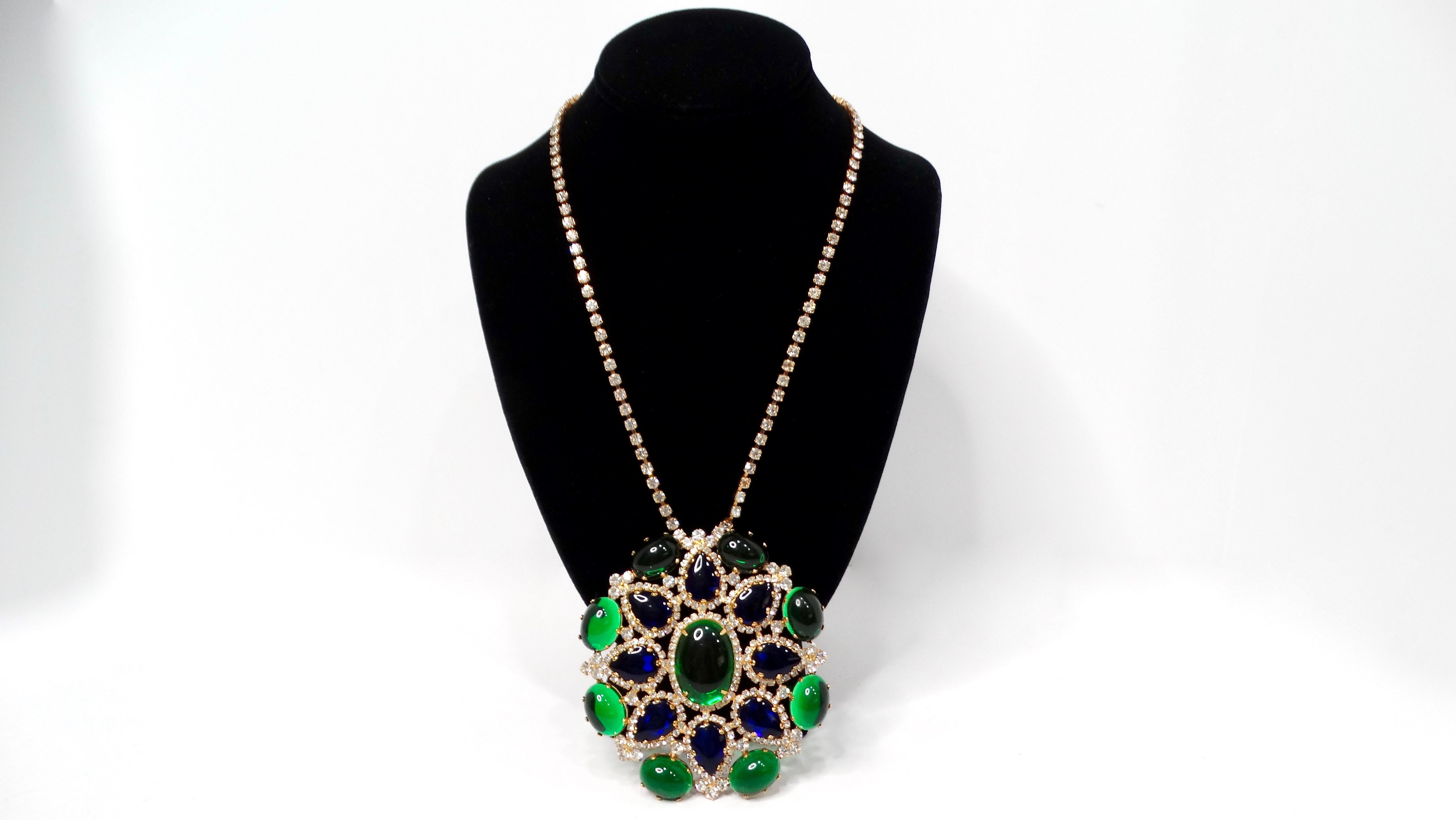Step back into the vibrant world of the 1960s with this captivating Kenneth Jay Lane Jewel-Tone Gripoix Style Rhinestone Pendant Necklace. This stunning piece features a large, eye-catching pendant crafted in the shape of a flower, adorned with