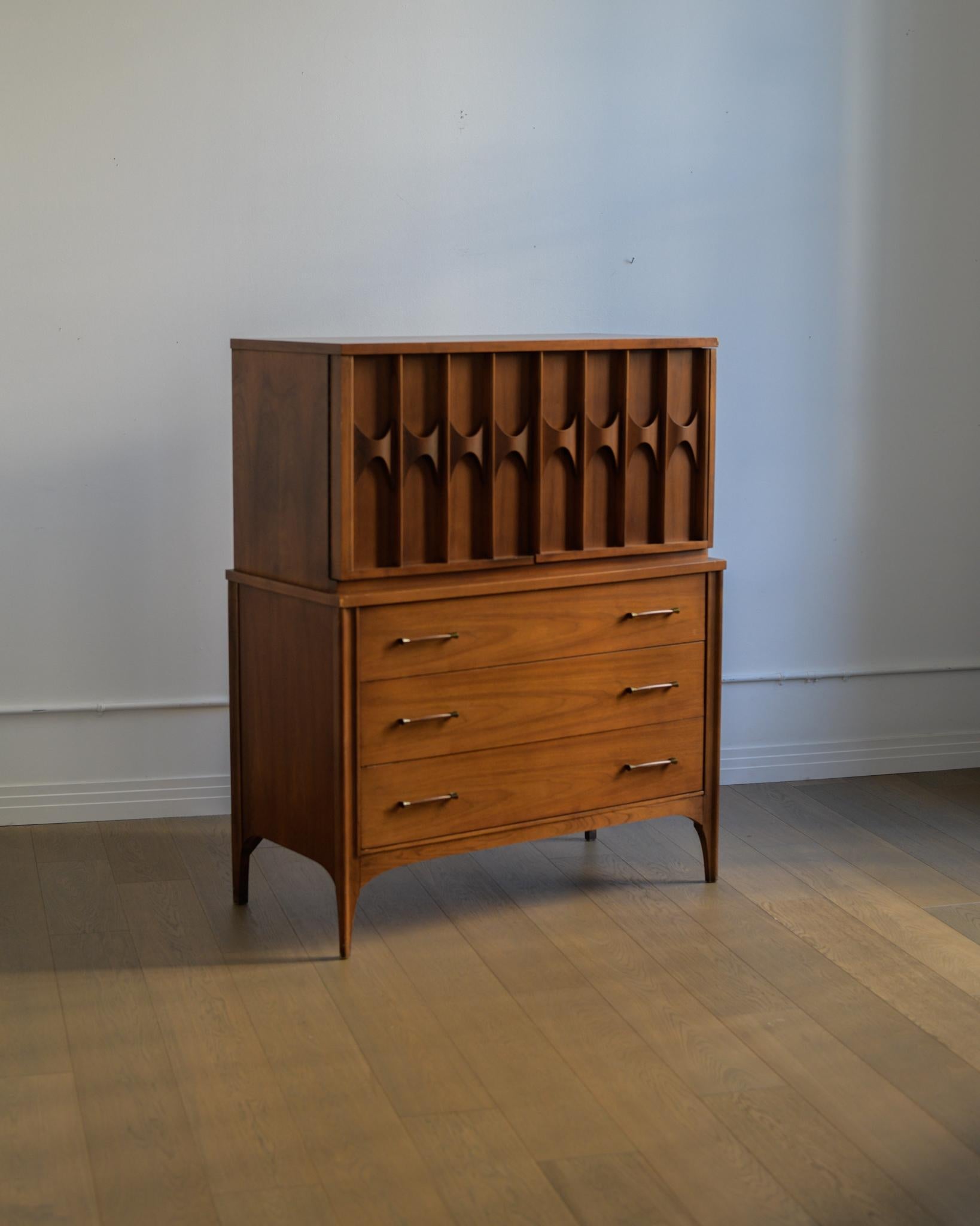 Bellissimo comò highboy Kent Coffey Perspecta del 1960. Un sacco di spazio con tre cassetti inferiori estraibili e due ulteriori + due ripiani nascosti dietro le ante superiori. 

In buone condizioni vintage con qualche segno di usura dovuto
