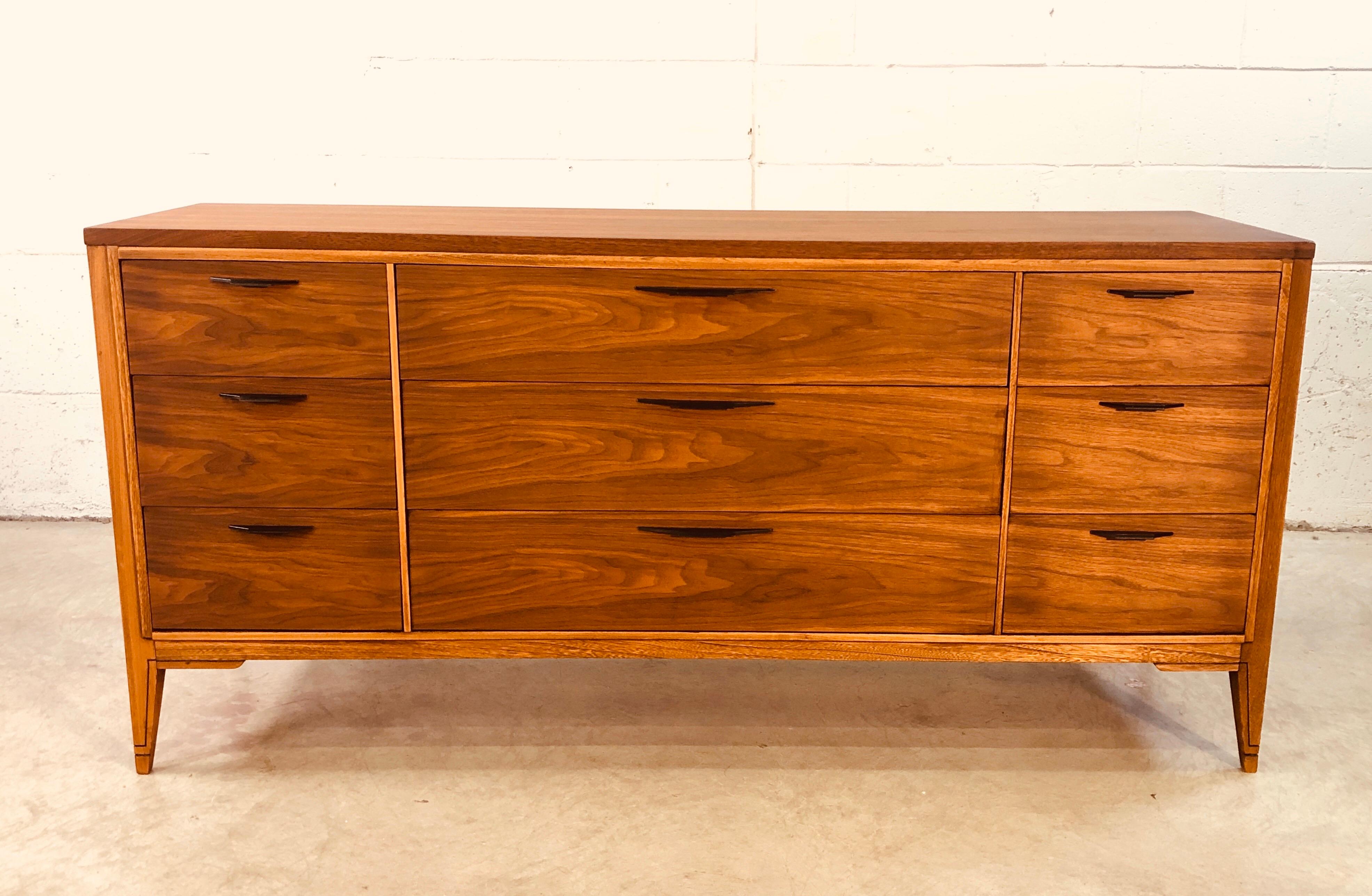 Vintage 1960s low walnut and elm wood dresser by Kent Coffey for the Tempo line. The dresser has nine drawers for storage. Three drawers are 4.25” H and six drawers are 5.25” H. Excellent refinished condition.