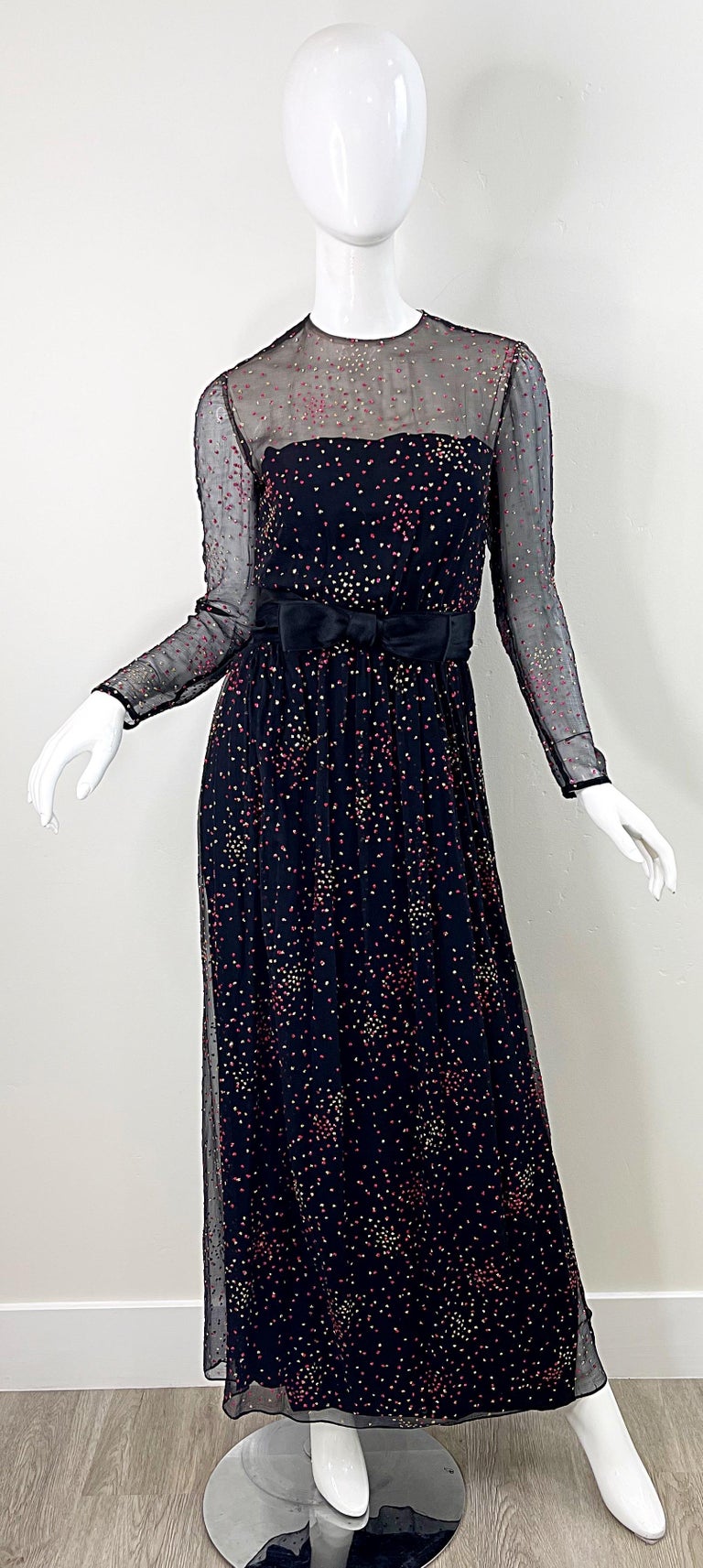 Beautiful 1960s KIKI HART black silk chiffon nude illusion evening gown ! Features sheer above the bust and sleeves. Full metal zipper up the back with hook-and-eye closure. Attached bow belt has hidden snap. Hot pink and gold glitter throughout (
