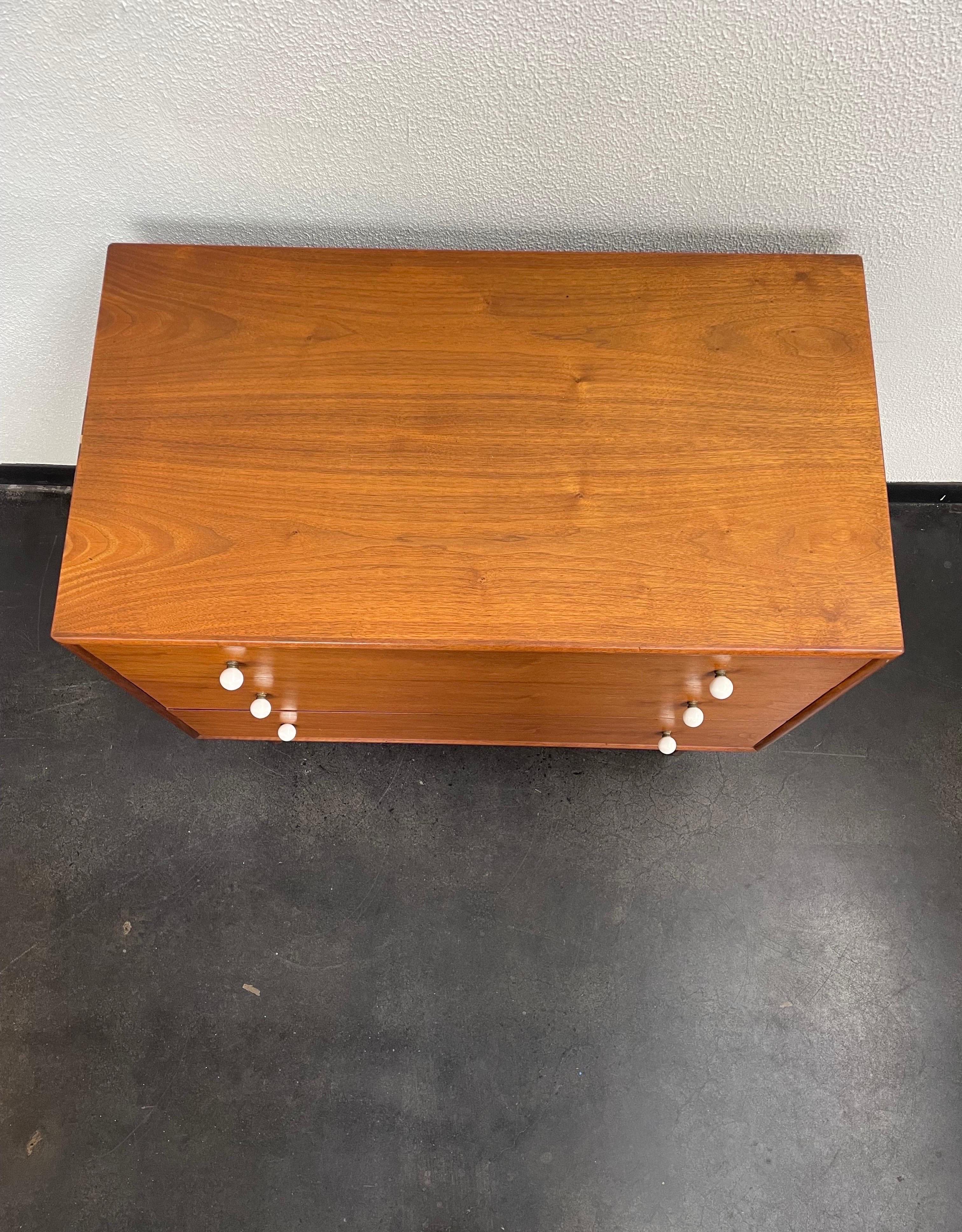 Vintage Mid-Century Modern chest/dresser. This beautiful walnut wood dresser is designed by Kipp Stewart for Drexel and features three drawers with the original porcelain knobs.