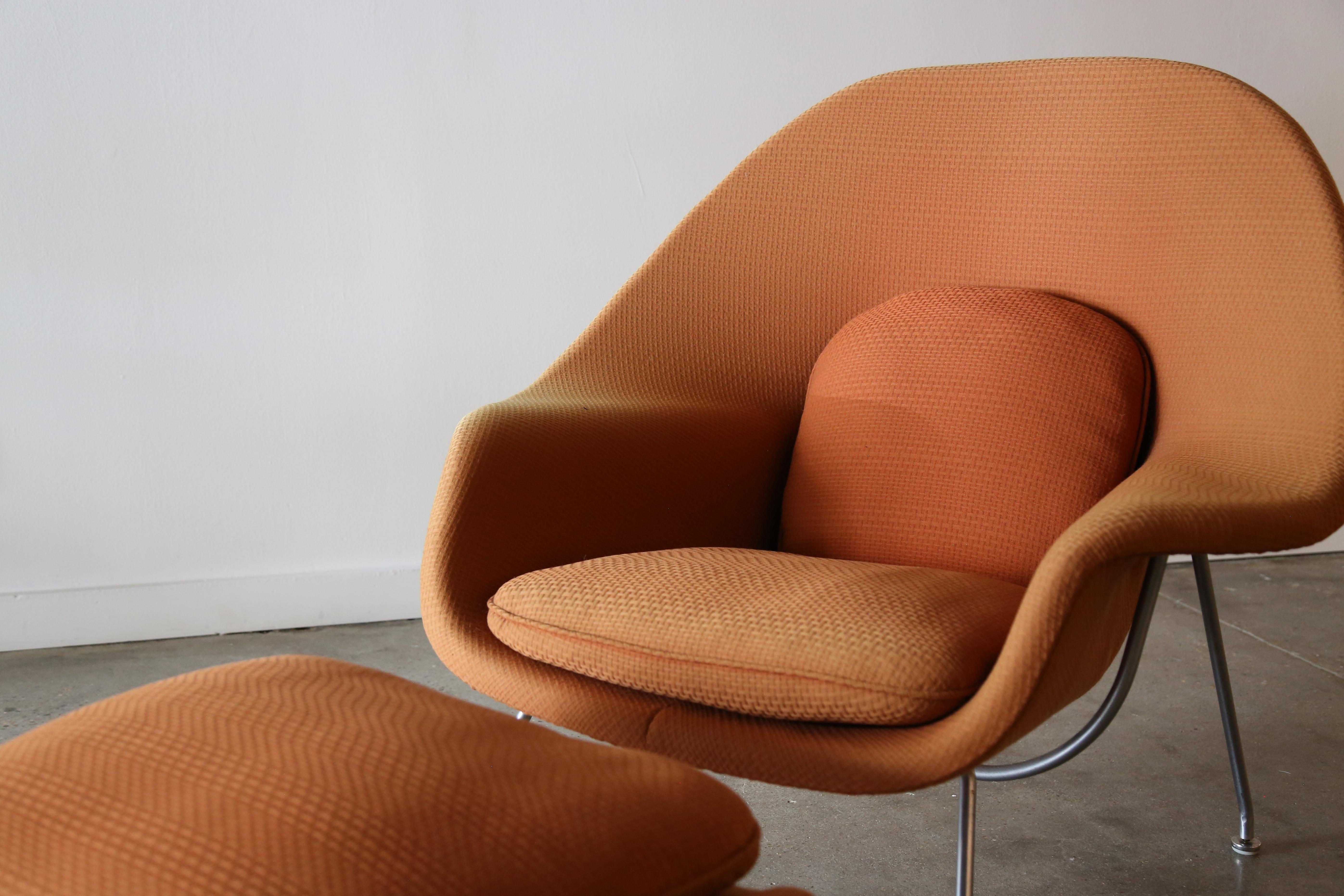 A 1960's Orange Knoll womb chair and ottoman designed by Eero Saarinen for Knoll. Reupholstered in the 1990s in a three dimensional checked orange fabric, in the appropriate hand stitched manner. This chair is unmarked but guaranteed authentic and