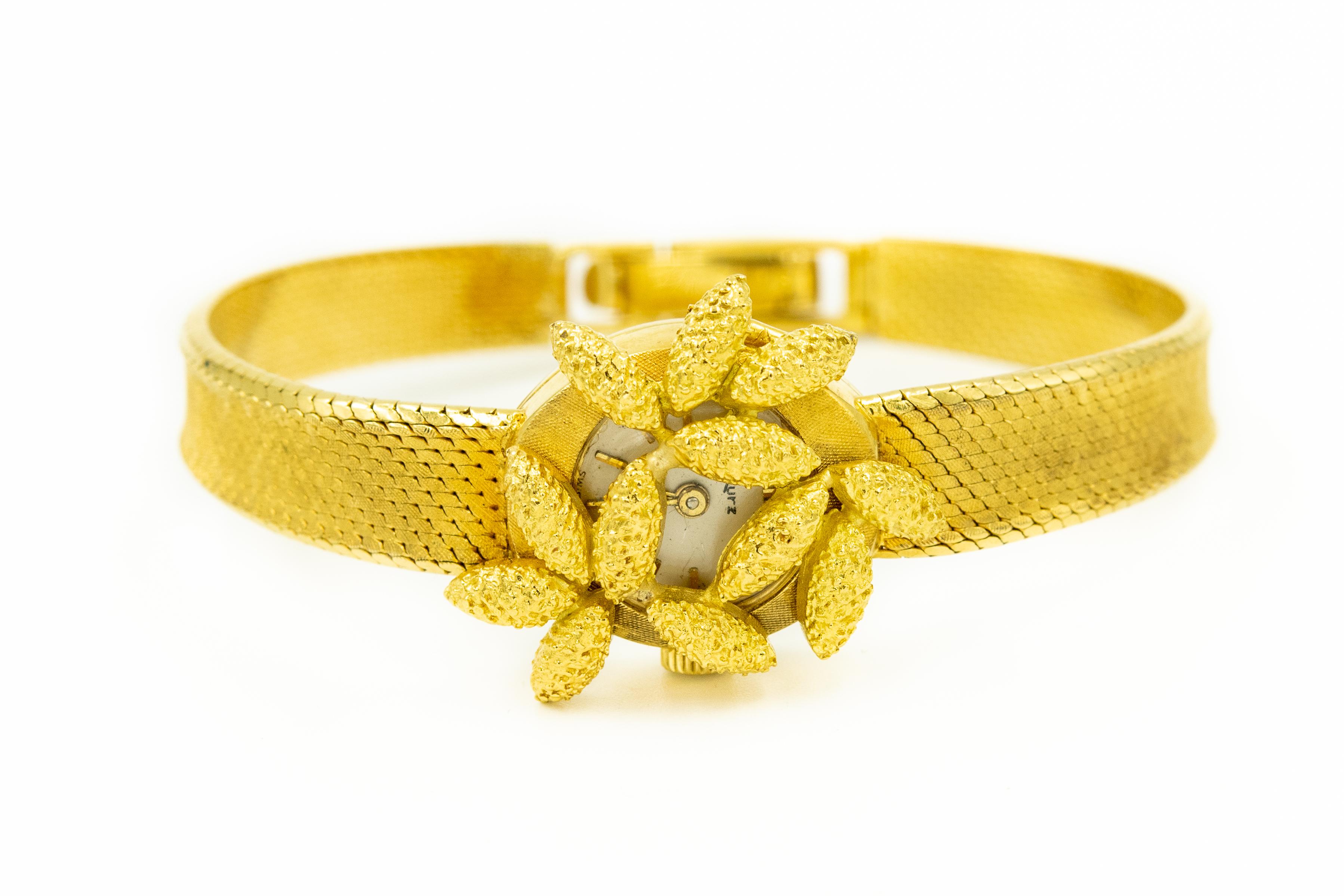 Stunning 18k yellow gold ladies watch by Kurz in Geneva featuring a hinged peek a boo style textured floral petal cover on a tightly woven design band that has a Florentine finish .  The floral section cover hinges at an angle to reveal the watch
