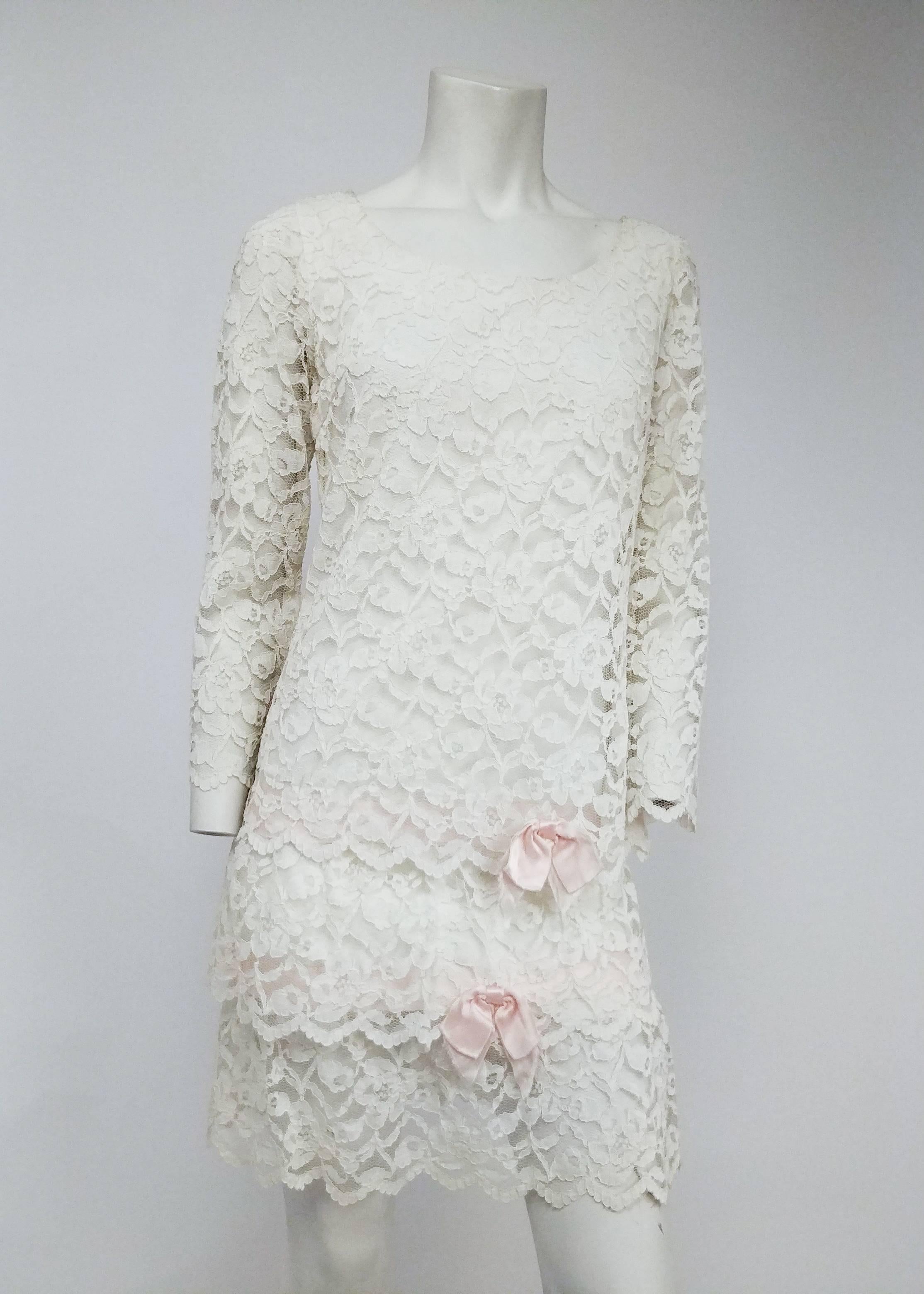 1960s Lace Drop Waist Dress. White lace dress with 3/4 sleeves and tiered skirt embellished with pink ribbon bows.  