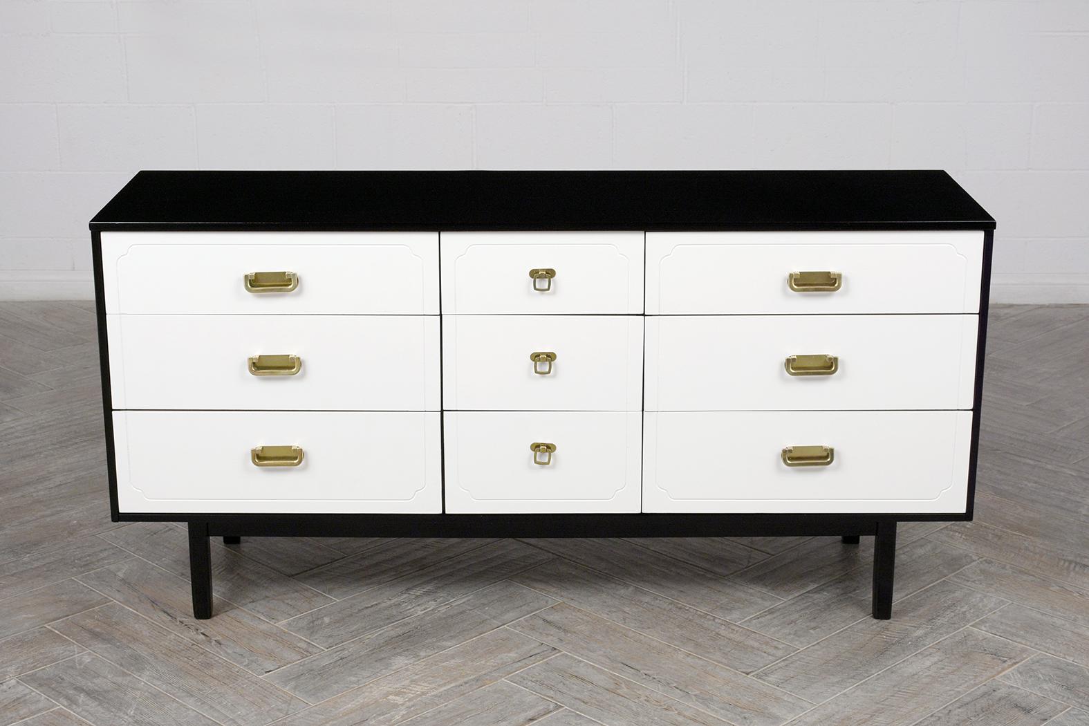 This 1960s Mid Century Modern Dresser has been fully restored is made from solid wood stained in a white & black color combination with a newly lacquered finish. The commode features nine drawers with brass polished pull handles, each side has three