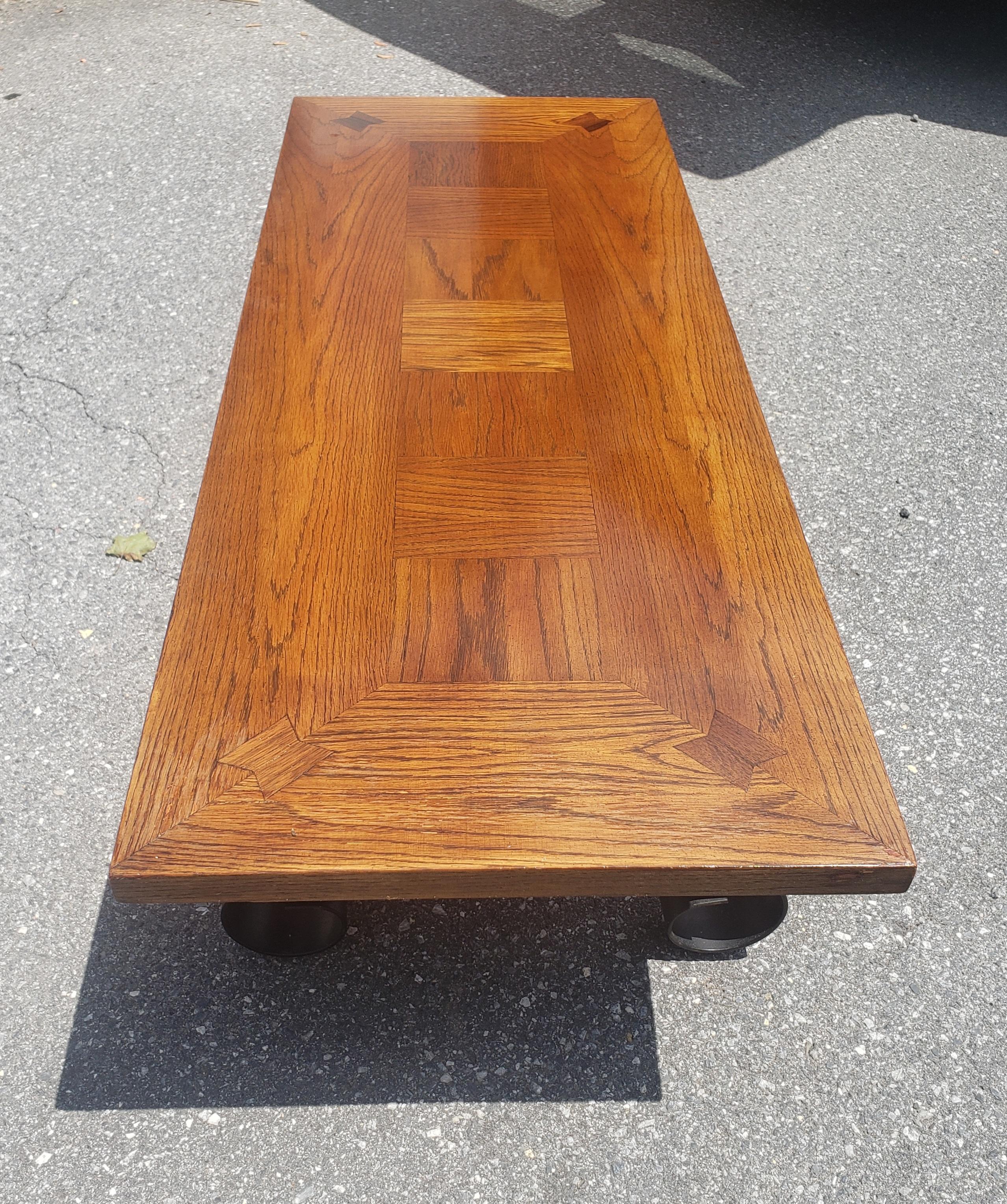 A 1960s Lane Furniture Oak Parquetry Coffee Table with scroll forged iron base painted black.
Measurs 56
