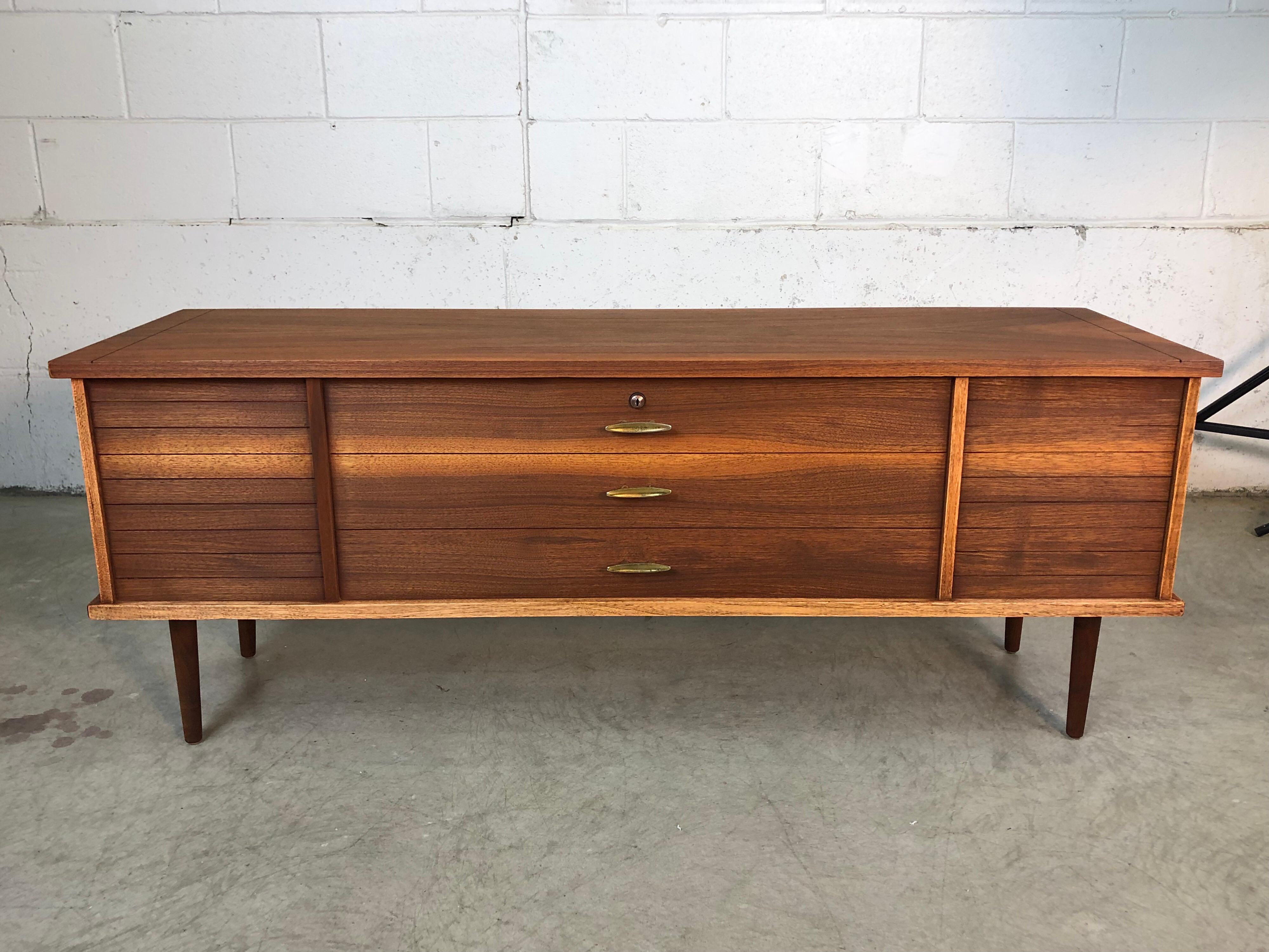 Vintage 1960s walnut wood cedar chest by Lane Furniture Co. The chest has round legs and faux brass pulls. It is lined with cedar wood and marked inside. The chest has been fully restored. The chest is compact and will fit into a small space.