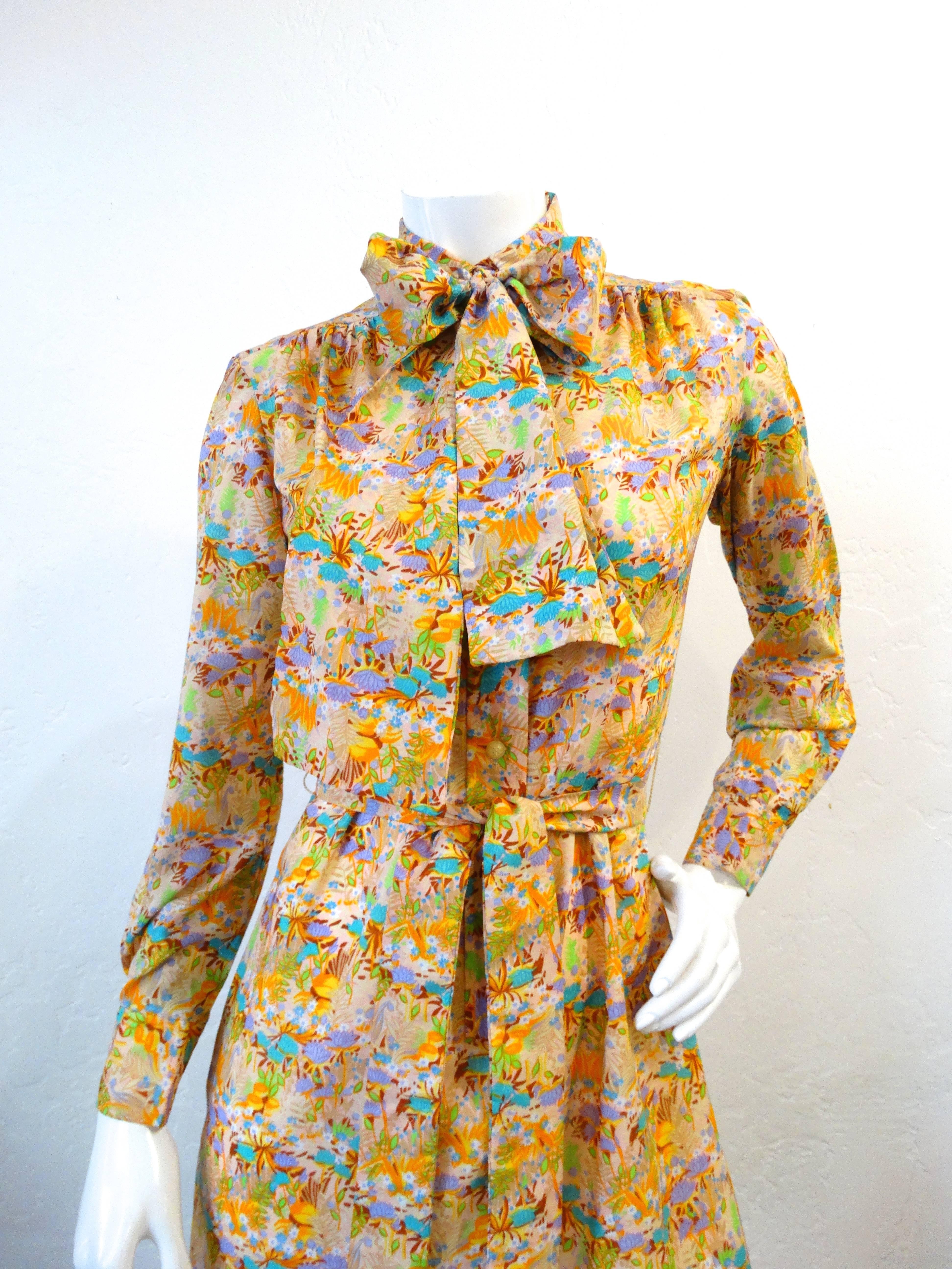 Incredible 1960s Lanvin button up dress! Vibrant multicolored floral all over pattern with pops of turquoise and orange throughout. Buttons up the front and at the cuffs. Ties at the waist for the perfectly cinched look! Adorable pussy-bow tie at