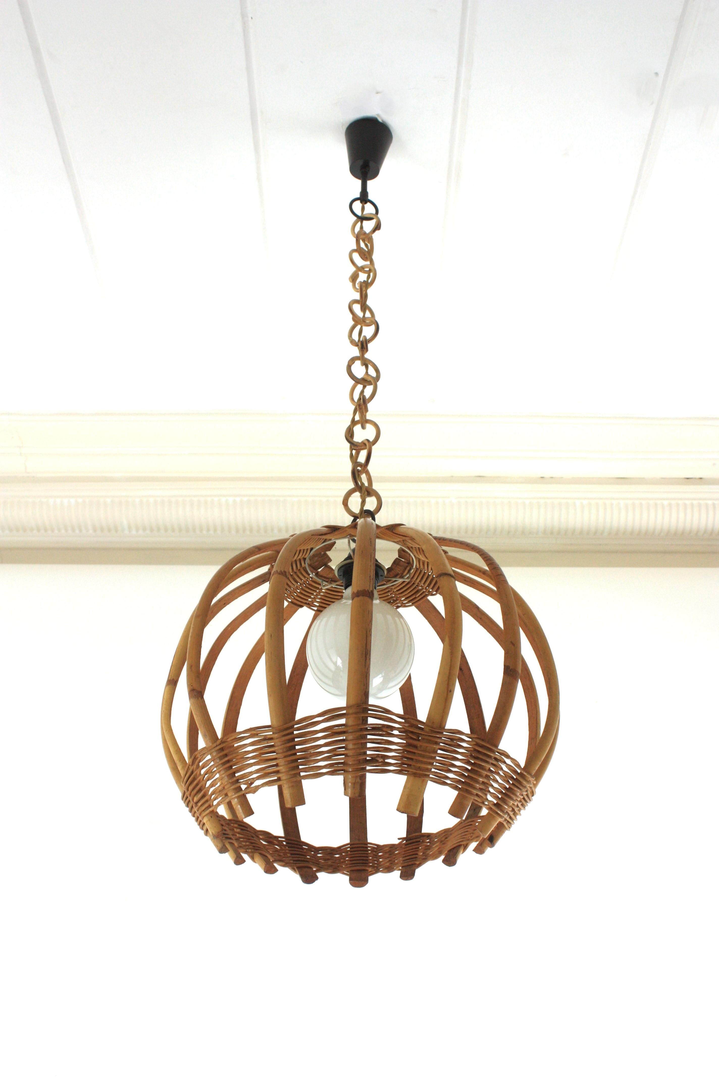Mid-Century Modern woven wicker and bamboo large pendant / hanging light. Spain, 1960s.
This beautiful suspension lamp features a bamboo rattan structure with vertical bars detailed with hand a tier of woven wicker at the top and at the bottom part.
