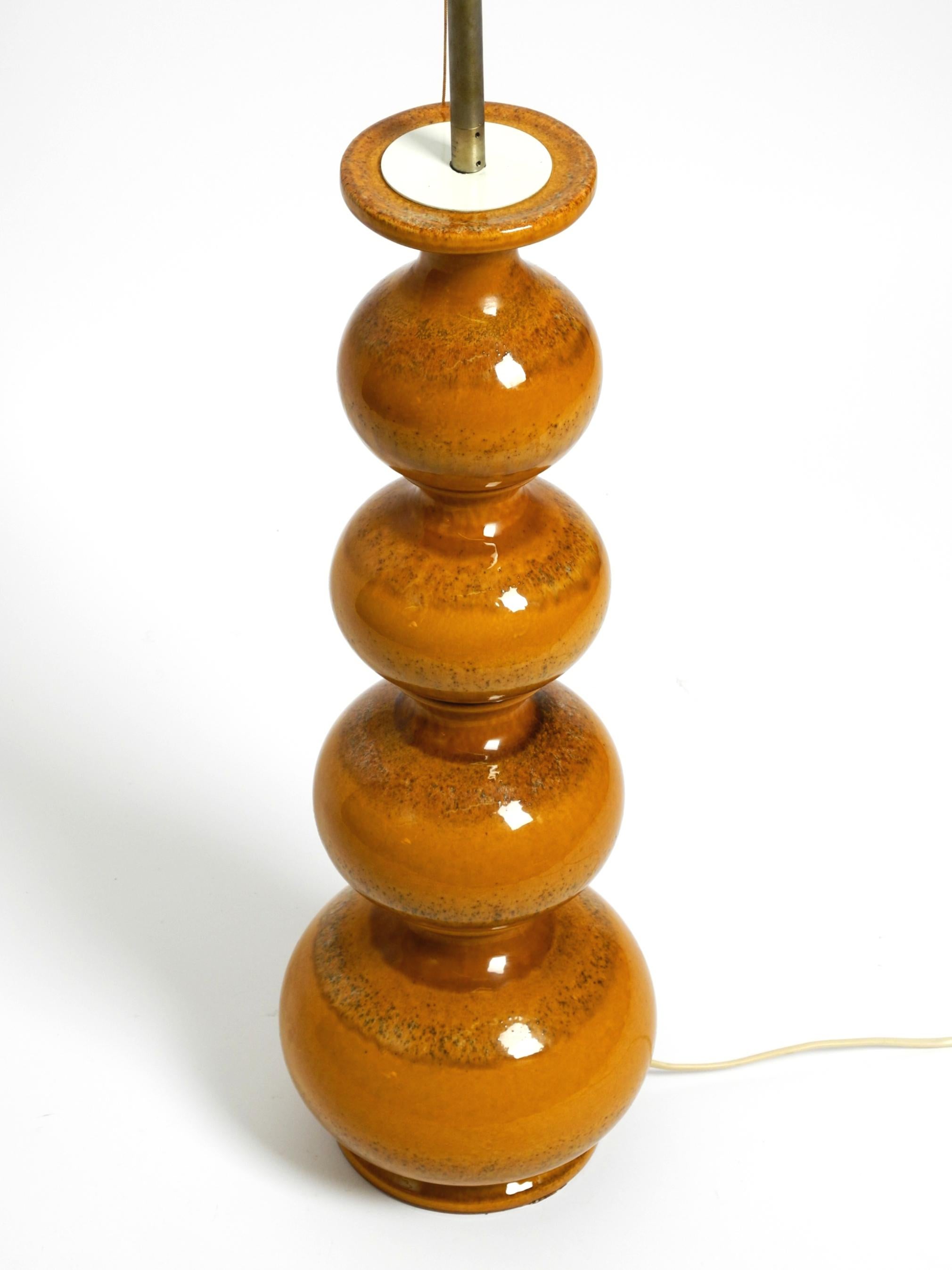 Beautiful 1960s large glossy ceramic floor lamp or table lamp from Kaiser Leuchte.
Made in Germany. Delivery without lampshade. 
Typical mid-century design. Solid and manufactured to a high quality. Beautiful light brown color.
It has two E27 bulbs