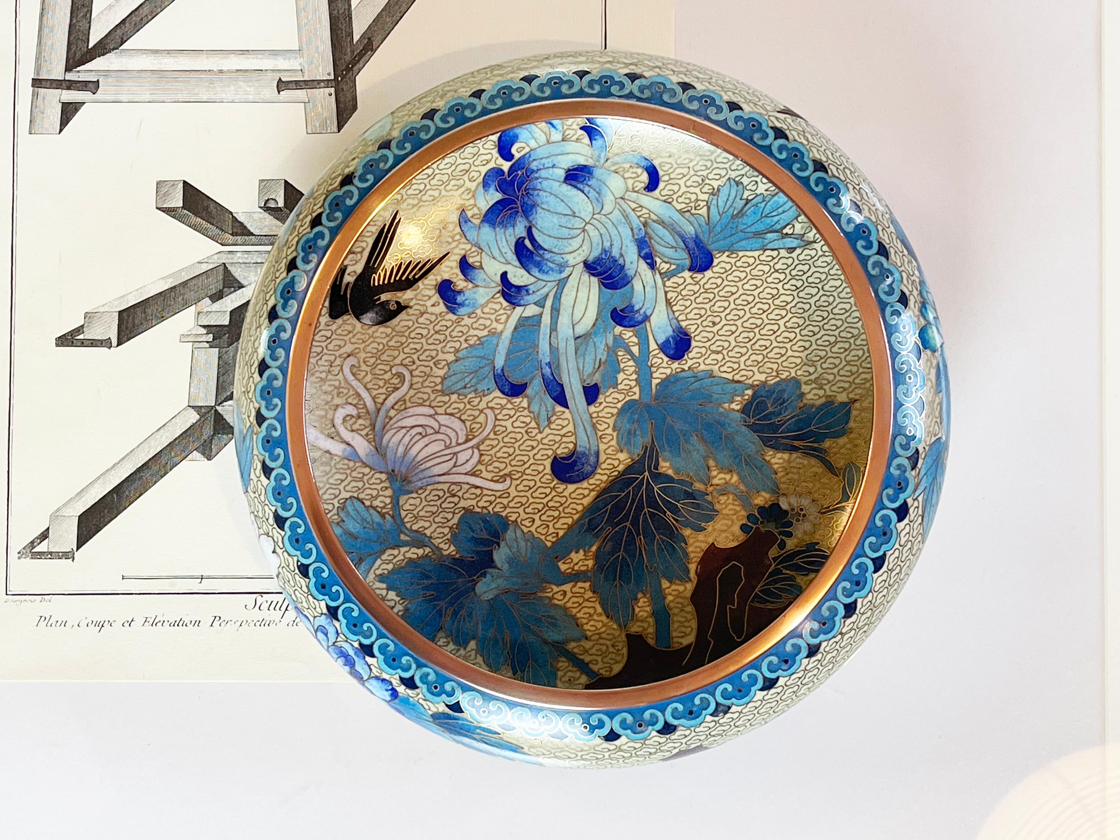 Expressive and intricately detailed Cloisonné bowl of decent size in beige, different shades of blue, black & grey.
The metal filigree in brass beautifully detailed with birds, Chrysanthemum and other flowers with leaves and some purple rock