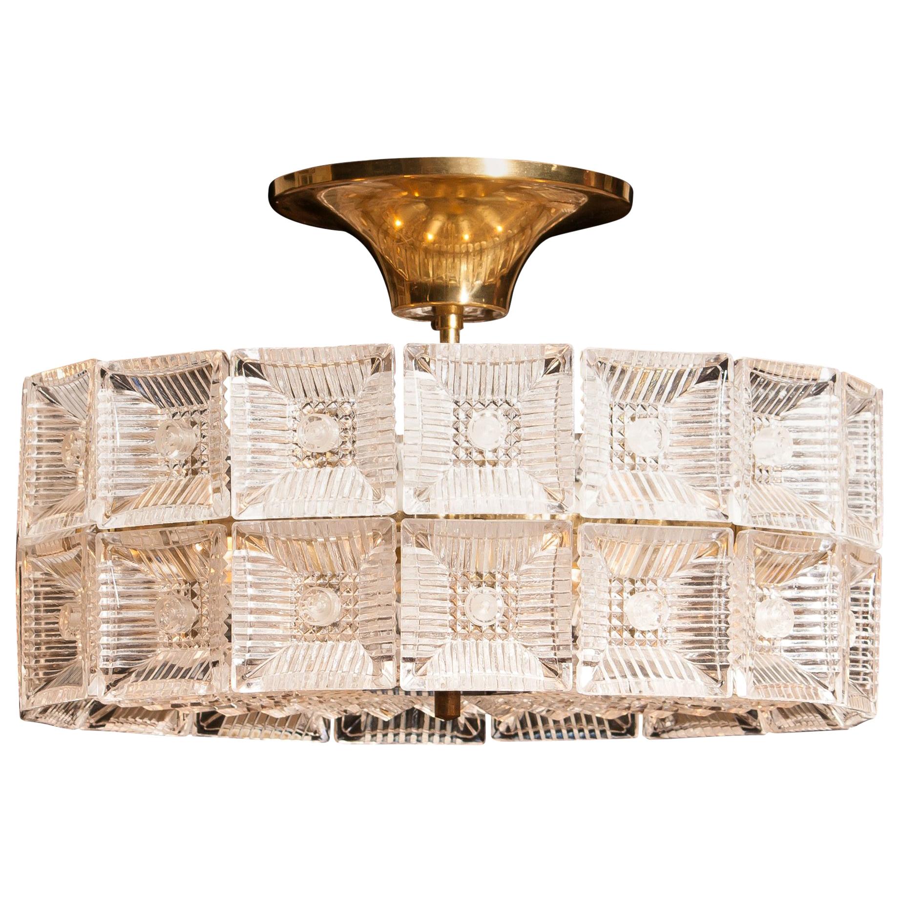 Magnificent ceiling light designed by Carl Fagerlund for Orrefors Sweden.
This lamp is made of beautiful brass and glass elements.
It is in wonderful condition.
Period, 1960s.
Dimensions: H 25 cm, ø 42 cm.
 