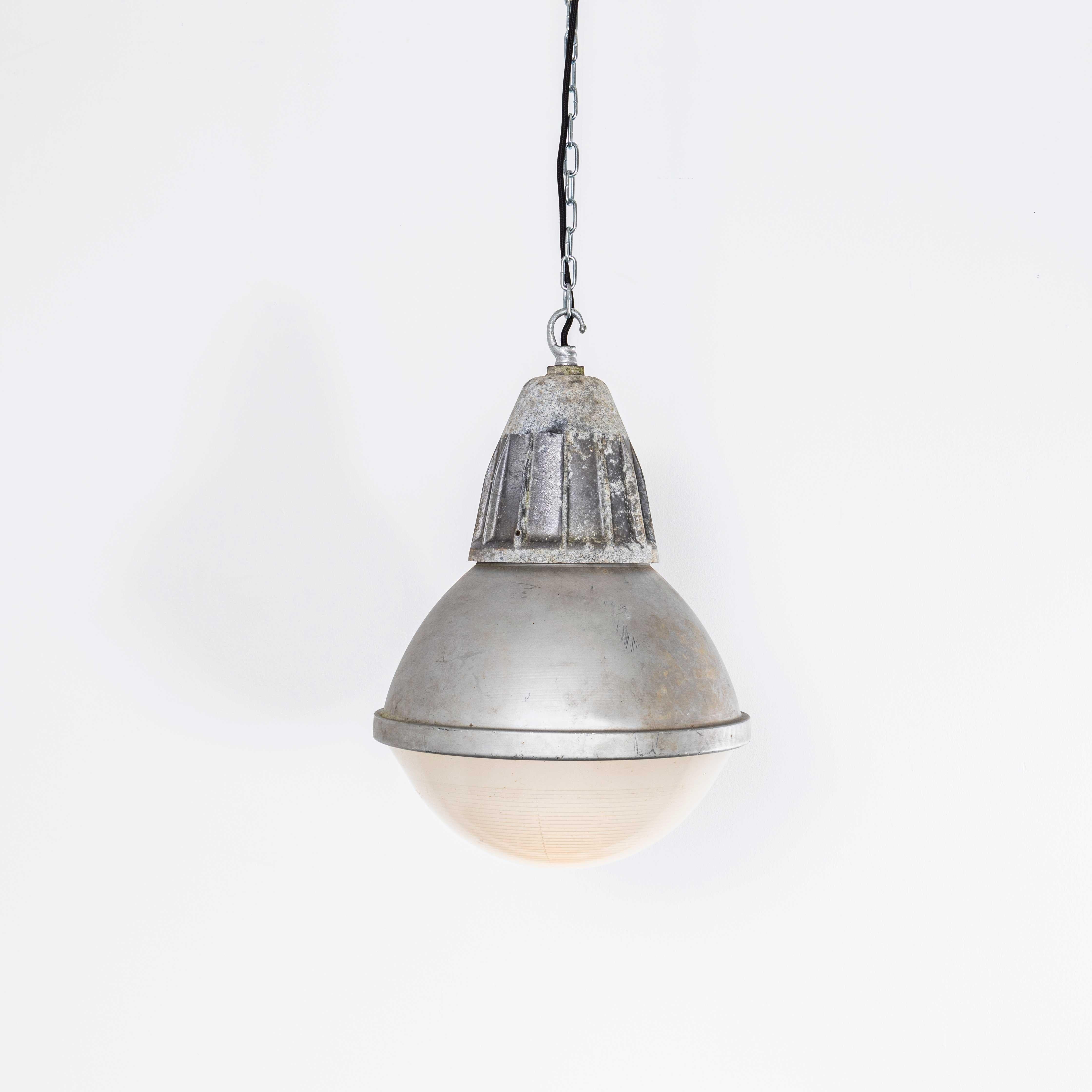 Lampade a sospensione industriali a globo Holophane di grandi dimensioni degli anni '60. 
Holophane è stata fondata in Francia alla fine del XIX secolo ed è famosa per aver inventato e perfezionato i riflettori in vetro borosilicato, spesso con
