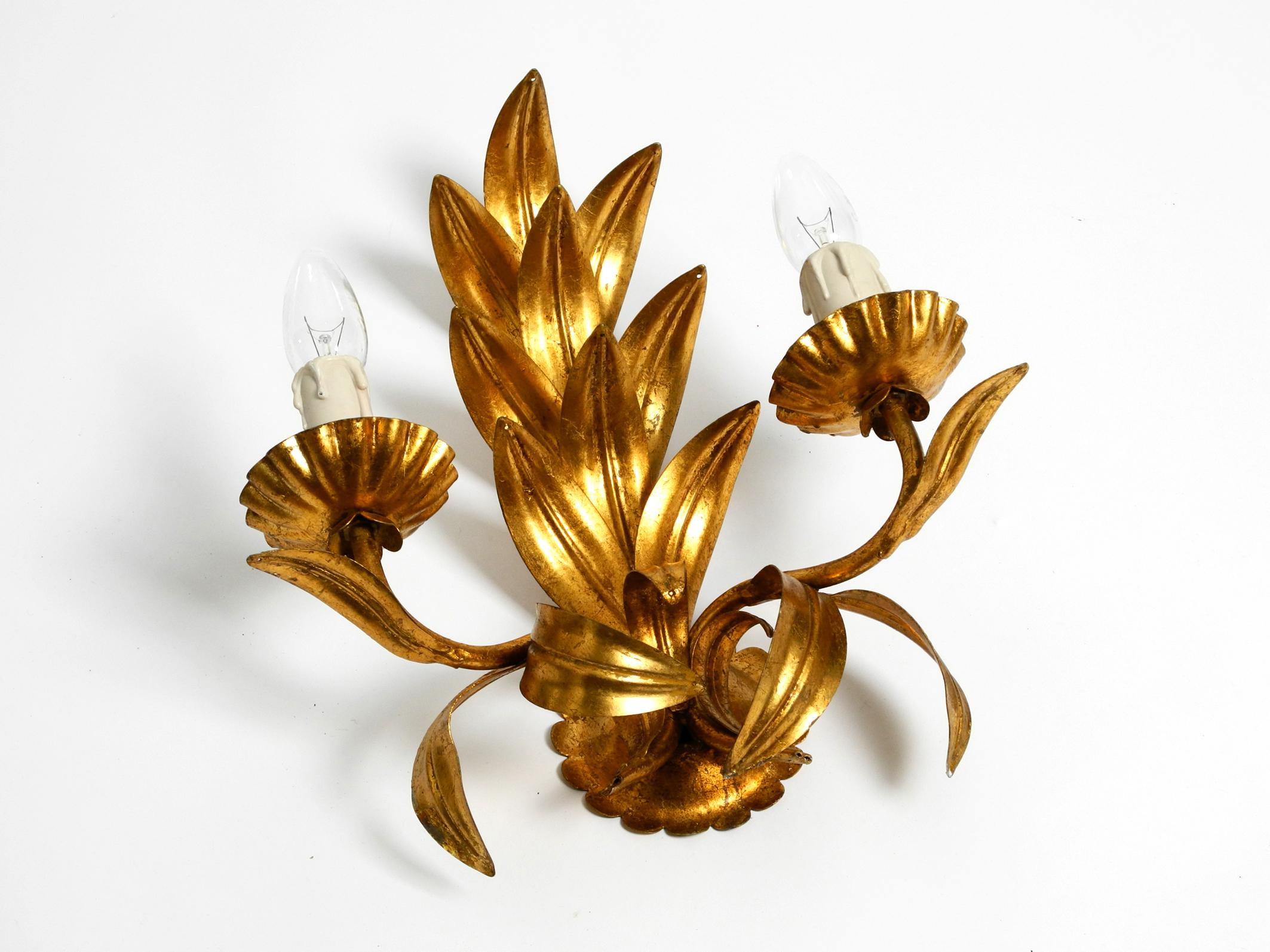 Rare 1970s large Florentine wall lamp with 2 sockets made in Italy.
Beautiful design with many details.
Many large curved leaves. Very high quality production.
Entire lamp is made of heavy gilded iron.
Fully functional and 100% original.
All