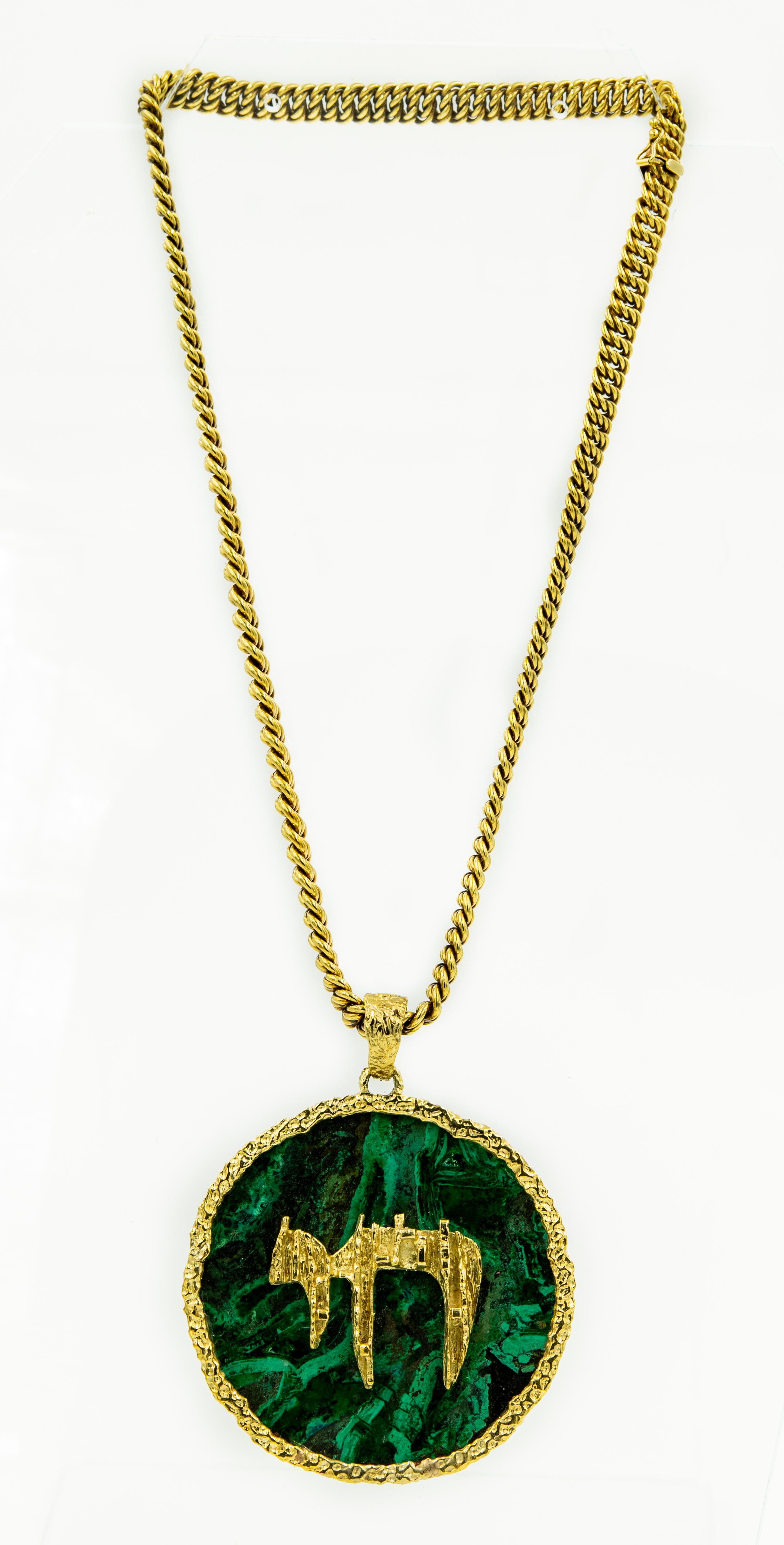 This impressive Jewish Chai necklace from Miami Rabbi Irving and Belle Lehrman's estate.  The pendant is in the brutalist style featuring a round piece of malachite in a handmade frame with a melted gold Jewish Chai applied to the center with a wide