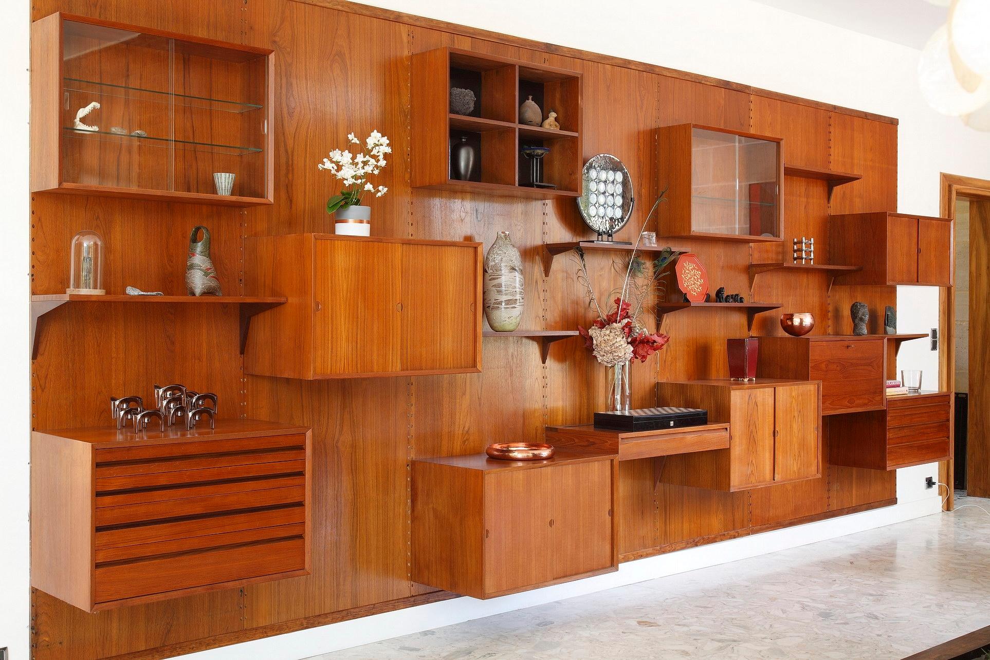 Poul Cadovius wall unit crafted of teak in the 1960s. This modular scandinavian shelving system consists of seven vertical panels with shelves and cabinet units:

- 7 shelves (P 22cm)
- 3 cabinet units with wood sliding doors (P46cm; H51cm)
- 1
