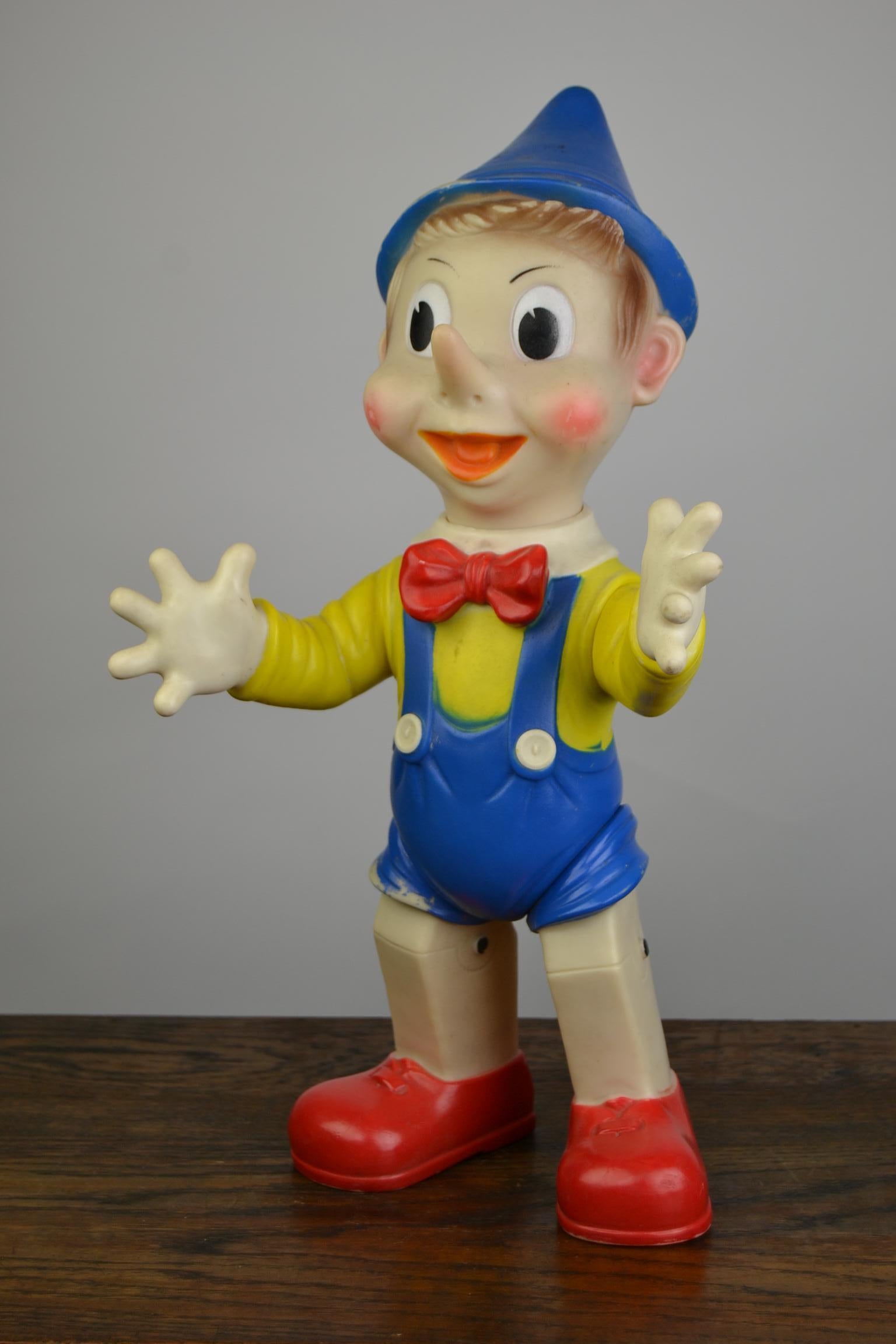 Large Rubber Squeaky Toy Pinocchio by Ledraplastci Italy. 
This 1960s Nostalgic Toy  has a movable head, arms and legs and his beeper still works. It's a large sized rubber squeak toy : 16.14 inch- 41 cm heigh ! 
This Toy Doll has the colors yellow,