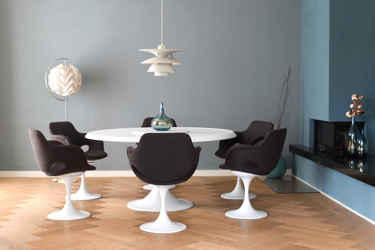 Scandinavian late 1960s dining-set. Tulip-shaped seating group consisting of 6 armchairs and a big round table. In the middle of the table a rotatable disc. White laquered metal and seats in dark grey fabric. Scandinavian / Denmark late 1960s.
Note: