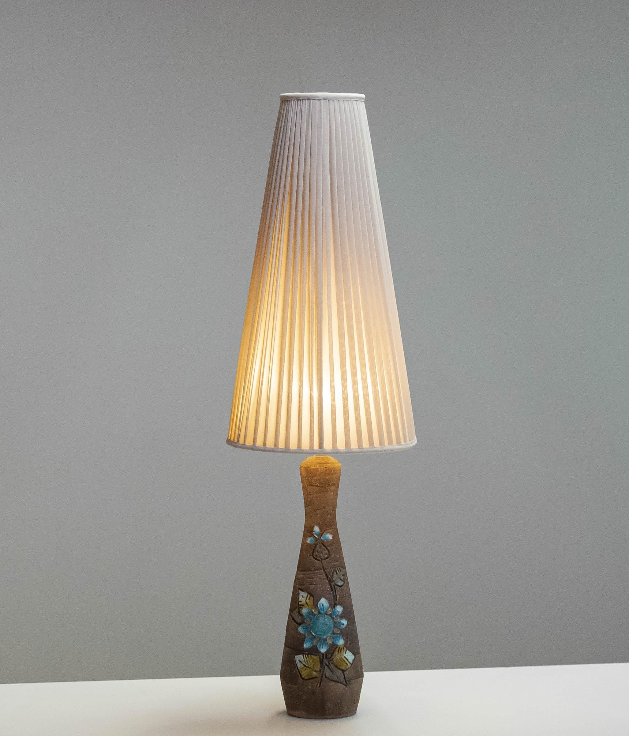 Magnifique lampe de table en grès de style semi-brutaliste par Tilgmans Keramic de Suède.
Les dimensions indiquées sont les dimensions totales, y compris l'abat-jour. L'abat-jour d'origine présente de légères traces d'utilisation. Ils sont visibles