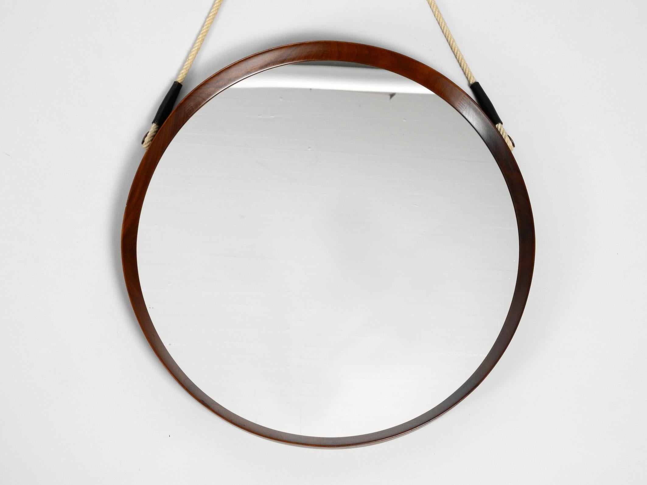 Round original 1960s large beautiful wall mirror with teak frame.
Made in Italy. The original thick rope for hanging is made of jute or sisal.
It is undamaged and firm.
Very high quality workmanship in a Minimalist Italian design.
100% original
