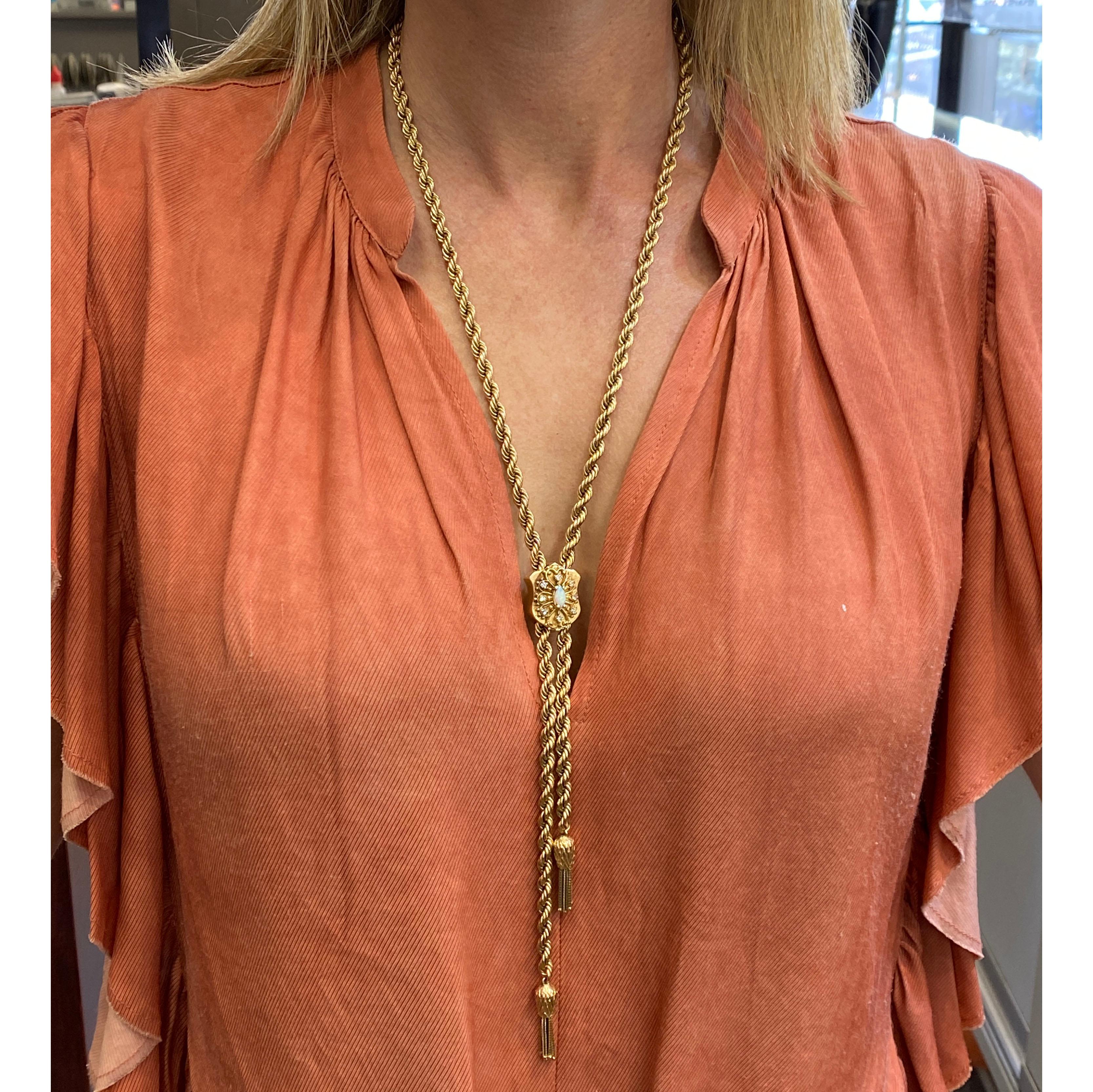 Diamond and opal lariat rope necklace fashioned in 14 karat yellow gold. The lariat features an opal and 8 single cut diamonds weighing .24 carat total weight and graded H-I color and VS clarity. The adjustable necklace measures 30 inches in length