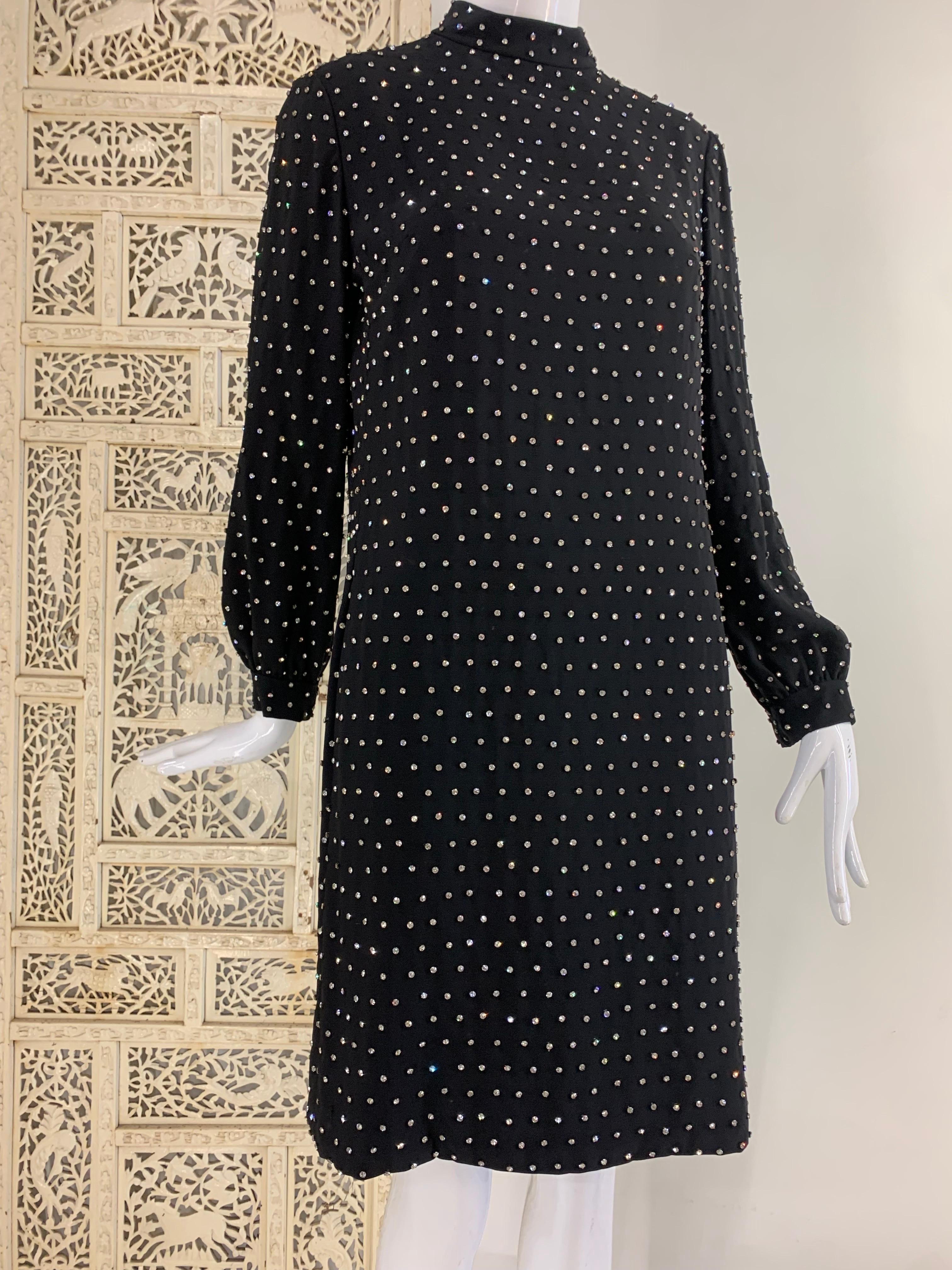 A fabulous 1960s Marie McCarthy for Larry Aldrich black rayon crepe cocktail mini dress:  banded neckline, sleeve gathered into cuff, darted with back zipper.  Fully lined.  Completely covered in hand-sewn rhinestones. Side slit pockets. Fully