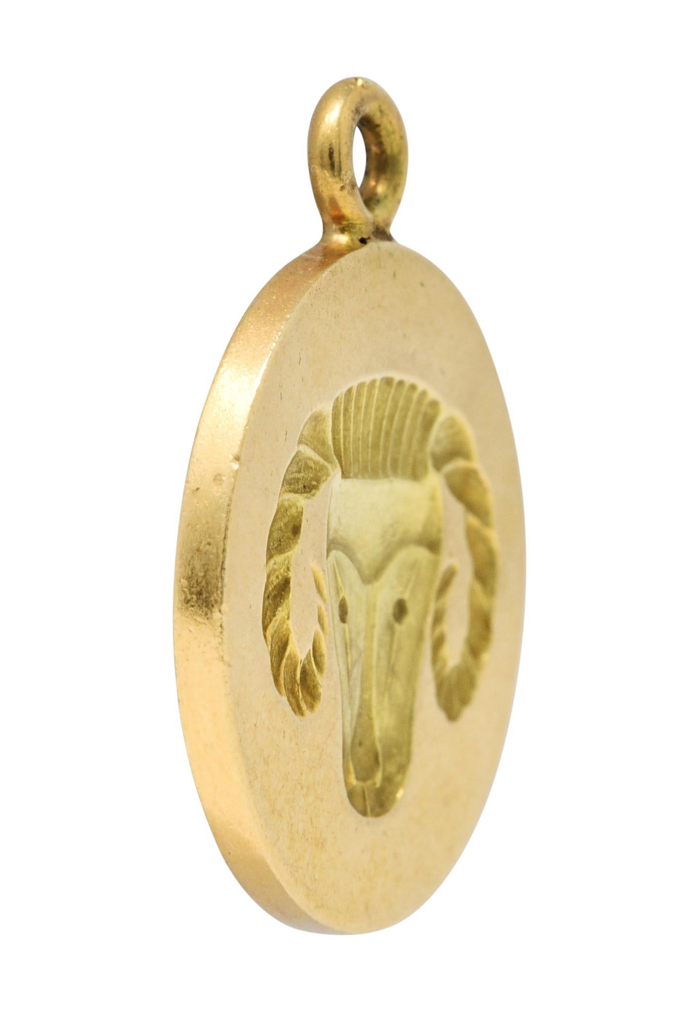 Circular charm features a deeply recessed impression of a ram

With twisted horns, a ridged crown, and a stylized face

Back is emblazoned with the Aries symbol and maker's mark

Stamped for Larter & Sons and 14 karat gold

Circa: 1960s

Measures: