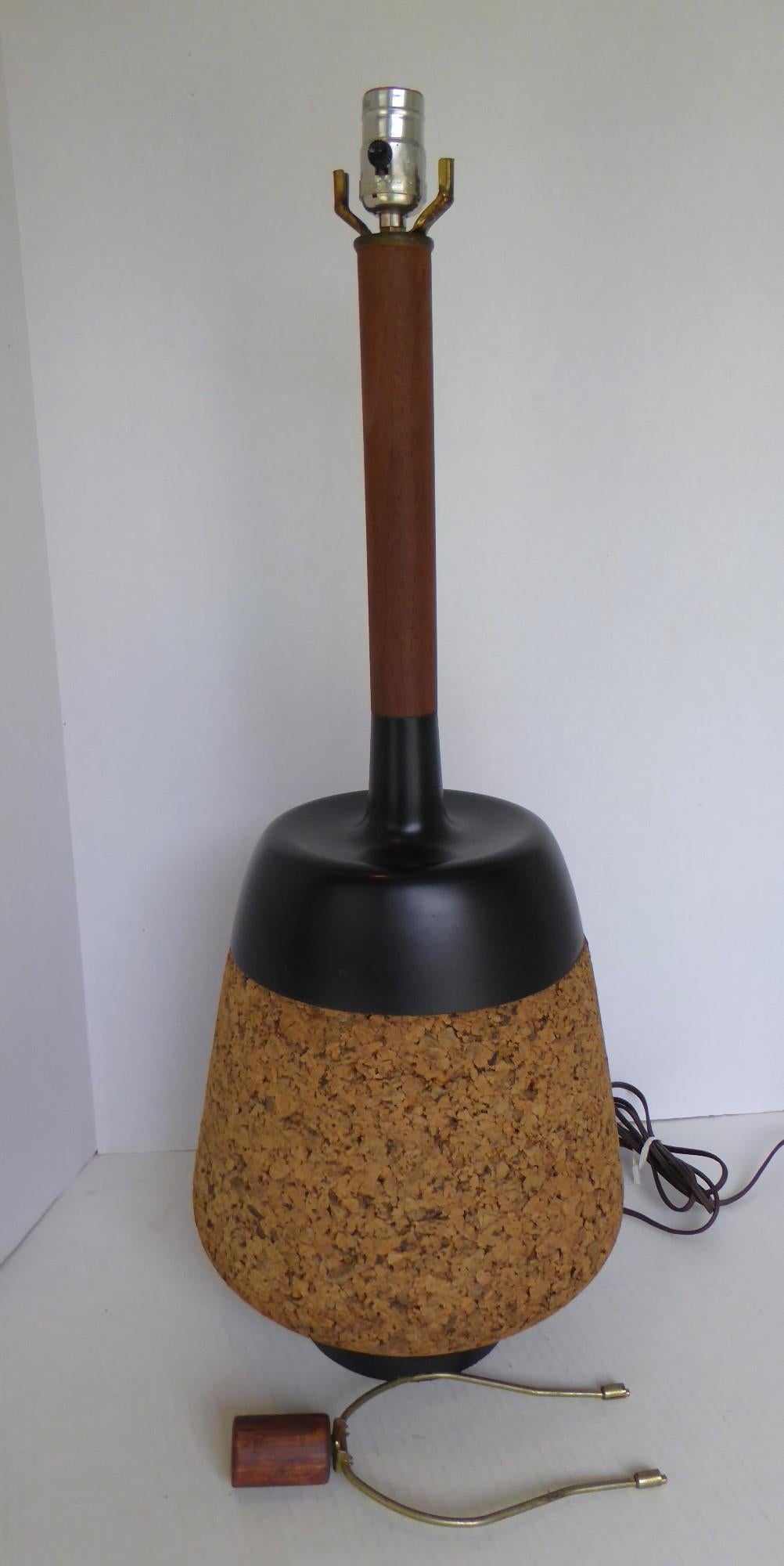 Dalla famosa Laurel Lamp Company del New Jersey, un'elegante lampada da tavolo in sughero/teak/metallo nero del Mid Century Modern. È stato progettato con un corpo bulboso in sughero sormontato da una coppa in metallo nero e da un collo in metallo