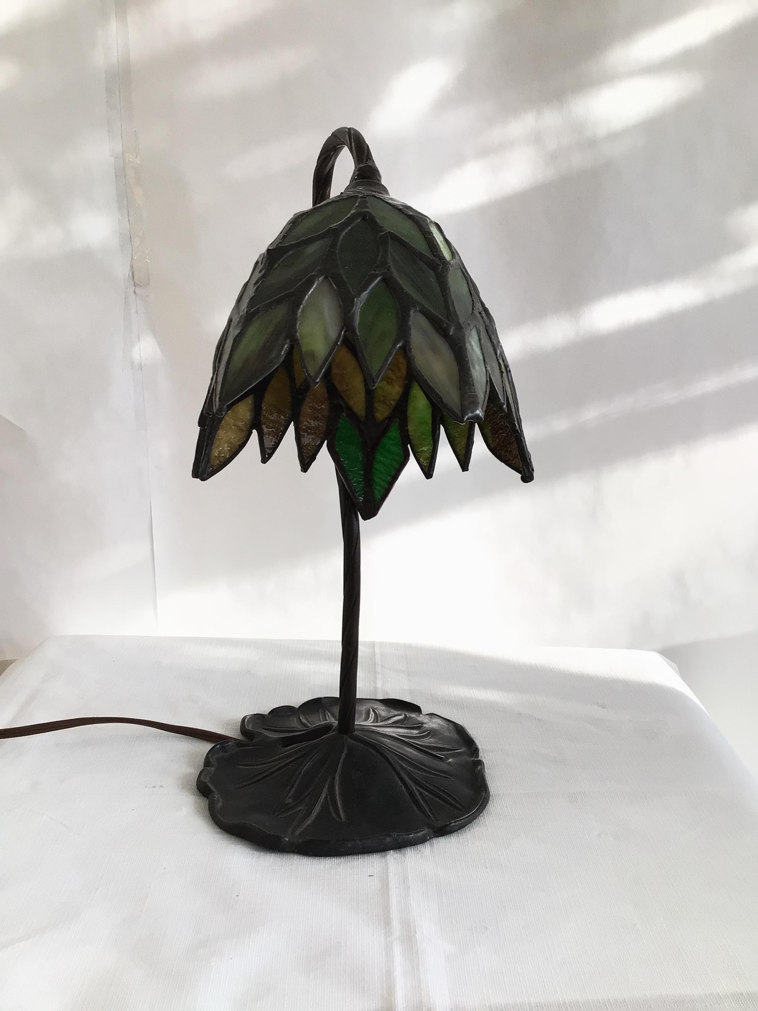 Lampe de bureau des années 1960 en verre teinté au plomb sur une base en métal en forme de nénuphar
Le câblage doit être refait
Couleurs : Vert, Noir Bronze 