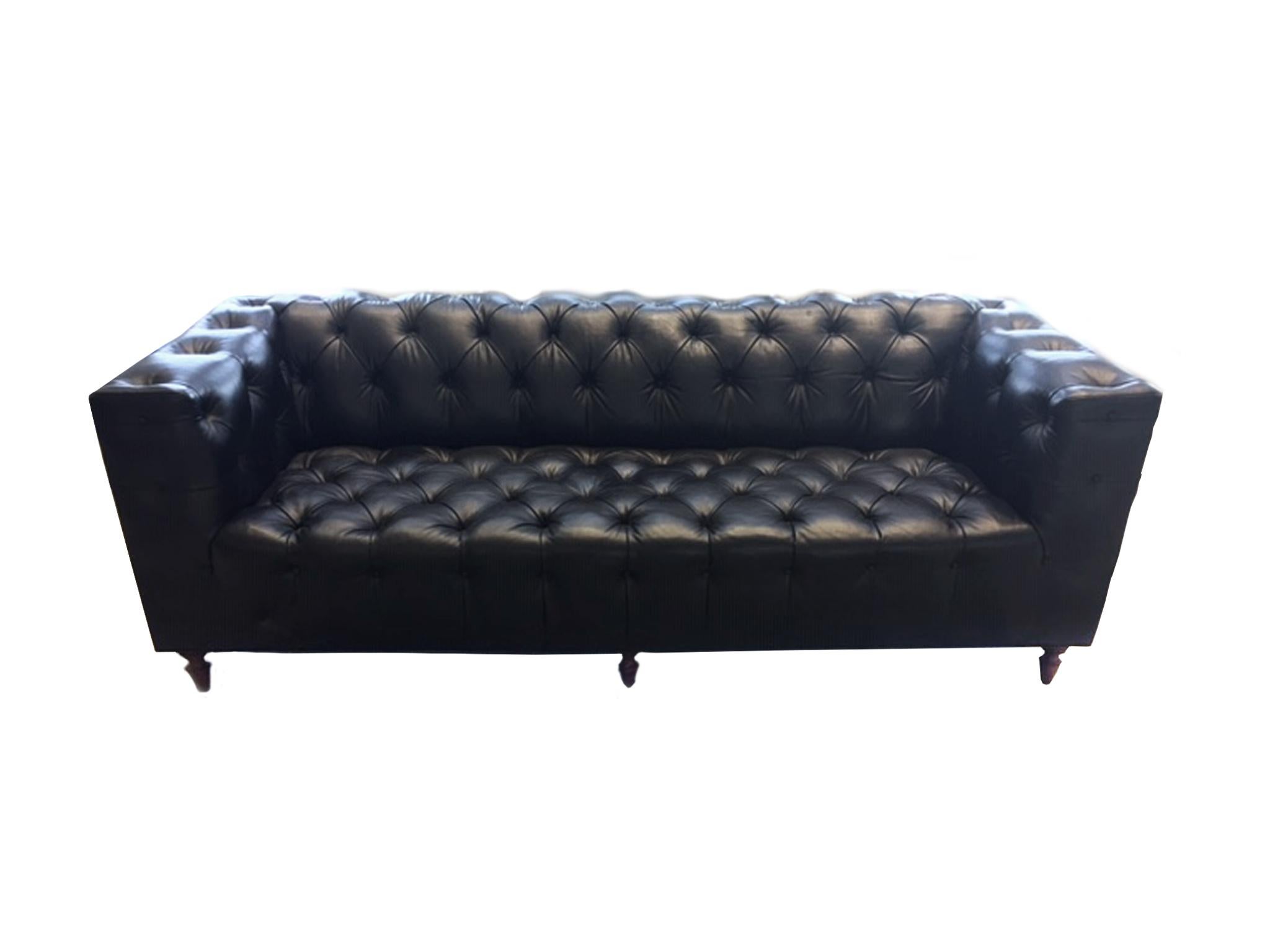 This black leather sofa was made in the 1960s, in the manner of Edward Wormley. It is a modern take on a classic: sleek, sharp lines are combined with the rounded forms of a traditional Chesterfield. The low back is constructed evenly with the arms.