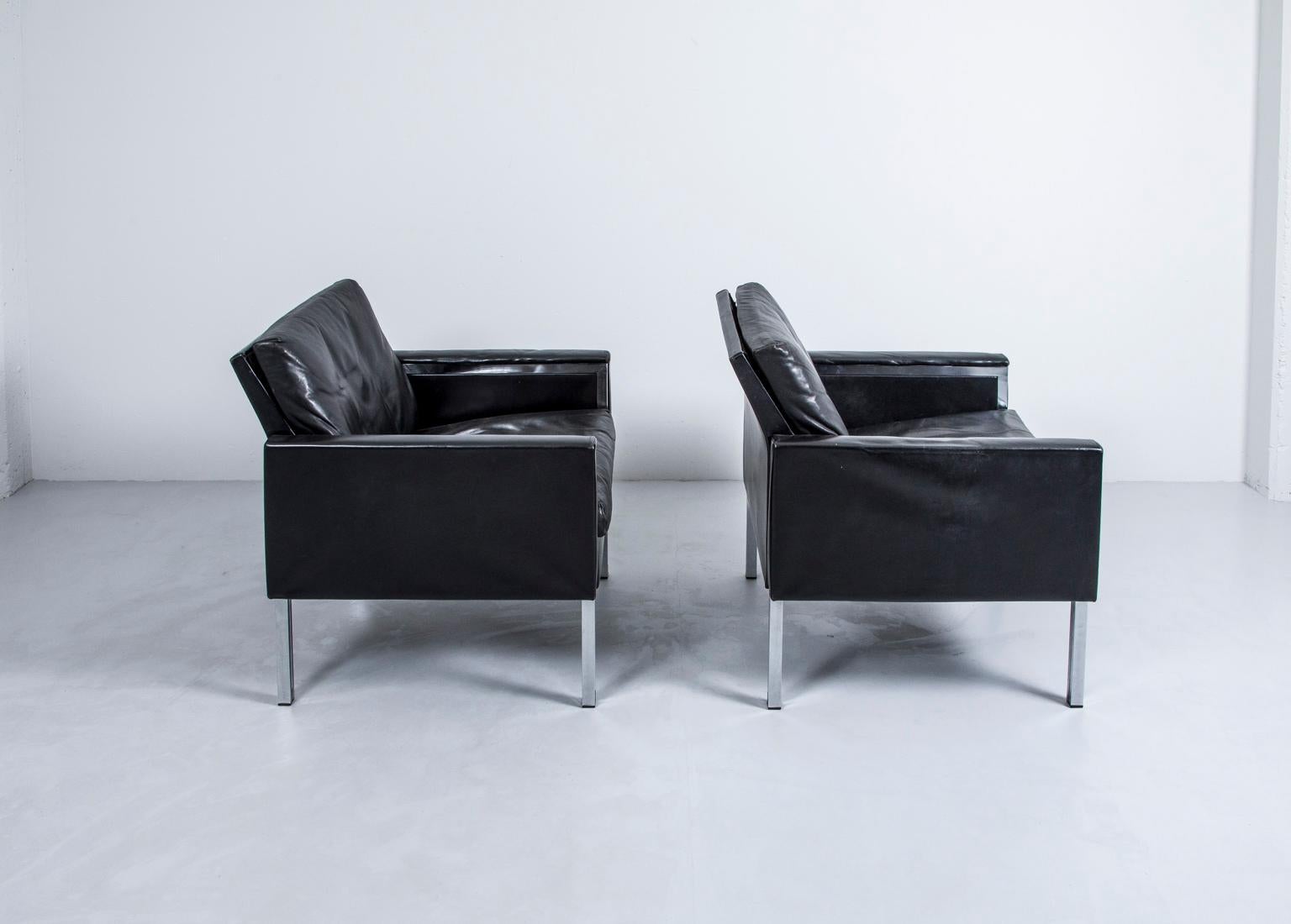 Pair of 1960s black leather lounge chairs with chrome details.