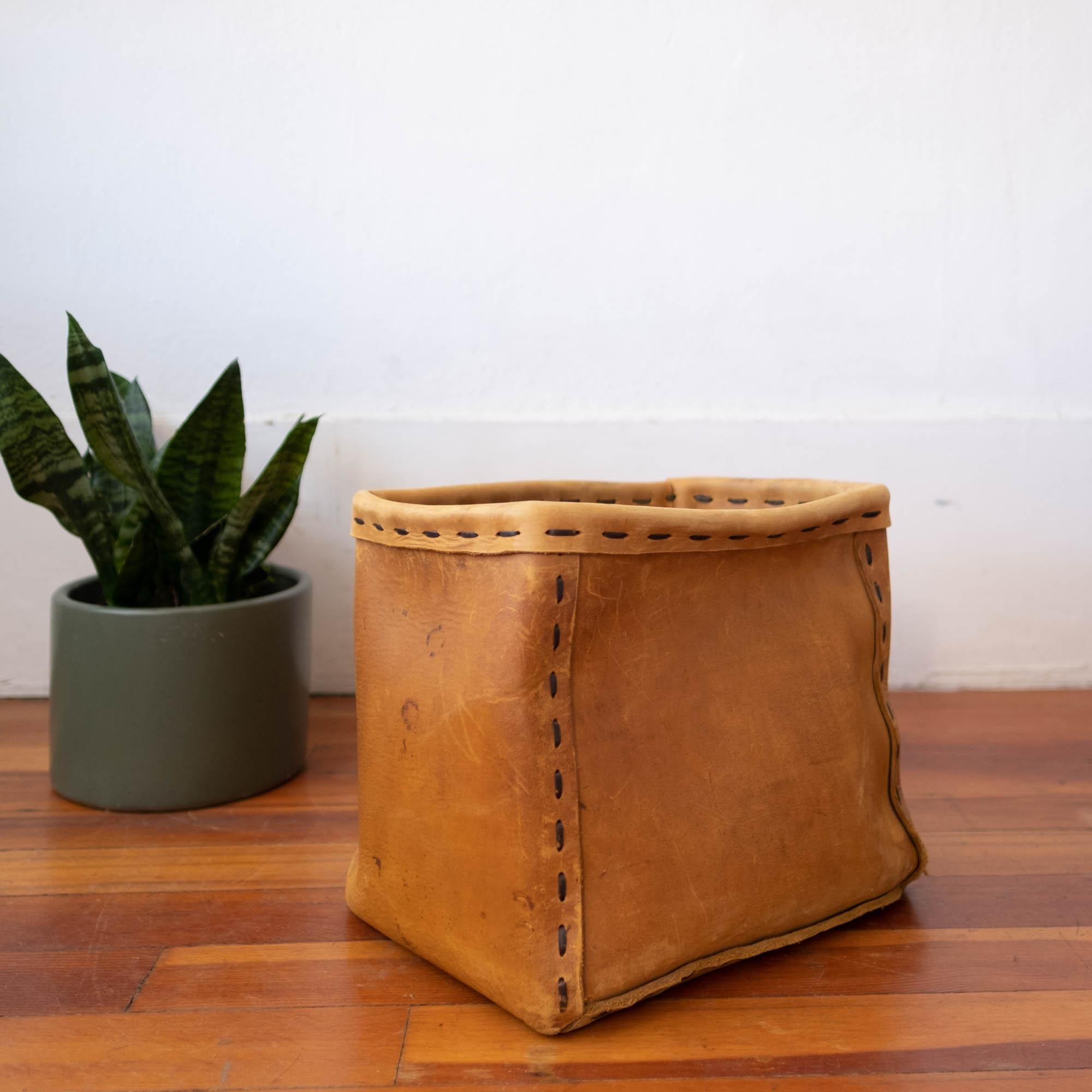 1960s handcrafted leather trash can. Thick leather with a metal piece under the top roll. Functional hippie chic.