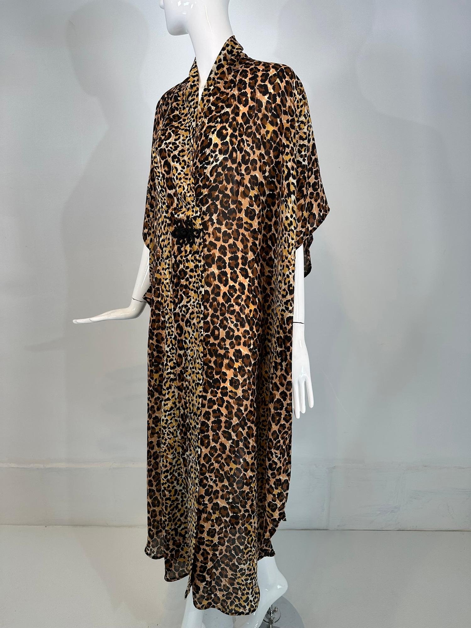 1960s Leopard pint crepe caftan robe by Marjorie Ellin Inc. Perfect for the pool or beach or entertaining at home. This caftan wraps at the front with a hidden Velcro closure and a decorative black fabric frog at the front. There is a single large