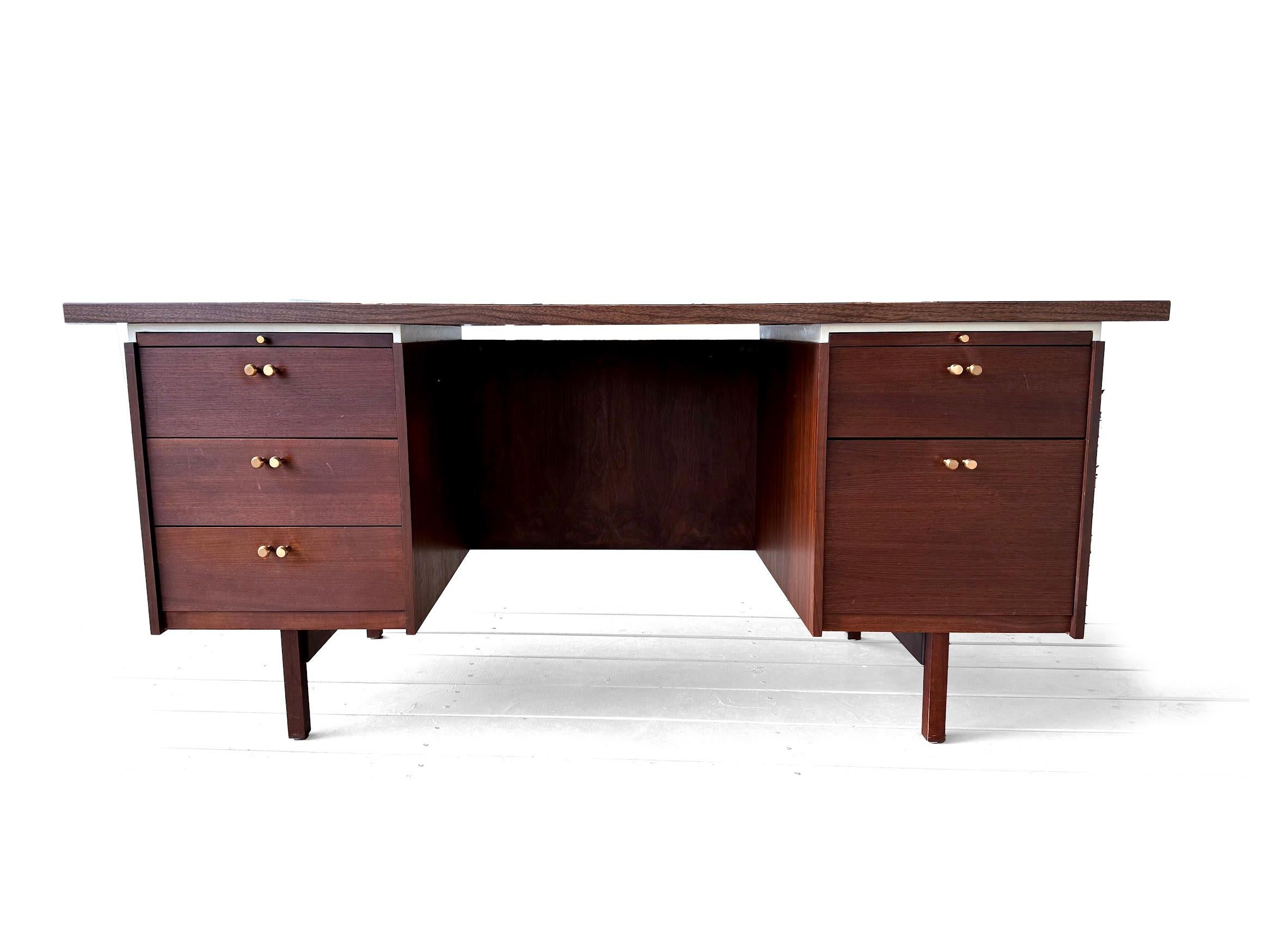 A Midcentury Modern executive desk with a conference size overhanging. Rand & Leopold Desk Company was an office furniture manufacturing firm which operated out of Burlington, Iowa, for 102 years before closing in 1990. Both pull out writing tablets