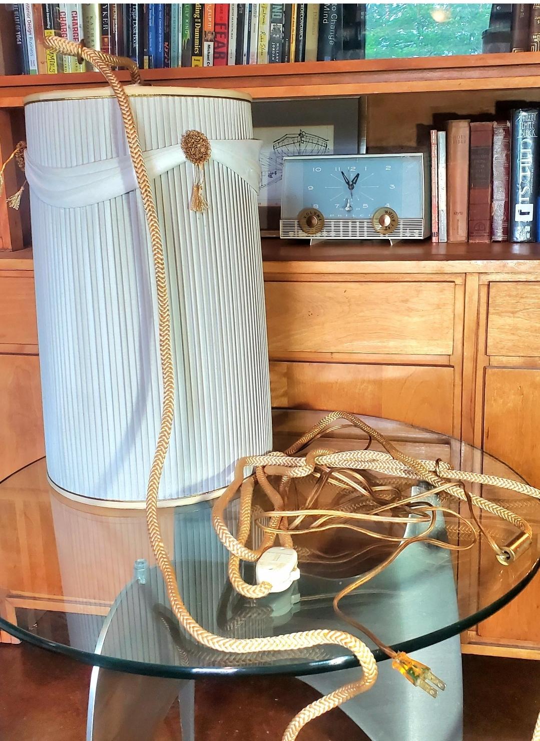 1960s
Leviton.
Puts a beautiful ambiance in a room.
Vintage pleated Drum swag lamp.
Gold metal florets.
Rope cord has 2 loops for hooks.
Rope cord is more than 10 feet, regular cord is another @6 feet.
Nice, quality working hardware. 