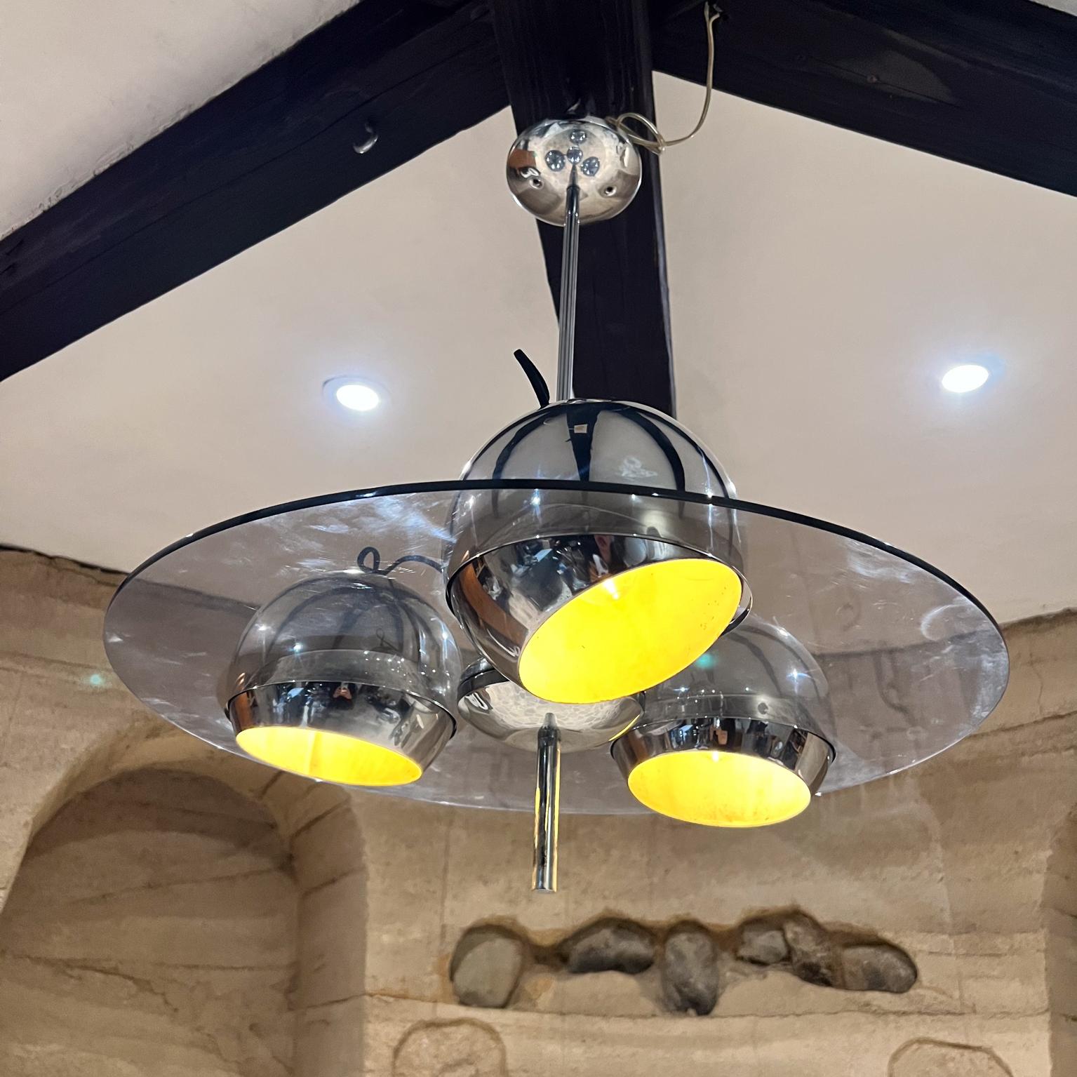 1960s MCM 3 Globe Chandelier Pendant Lamp
adjustable chrome-plated lights; allowing for controlled light direction.
Mounted on smoke plexiglass shade.
Unmarked, attributed Lightolier.
27 h x 23.5 diameter
The drop from the ceiling is 25