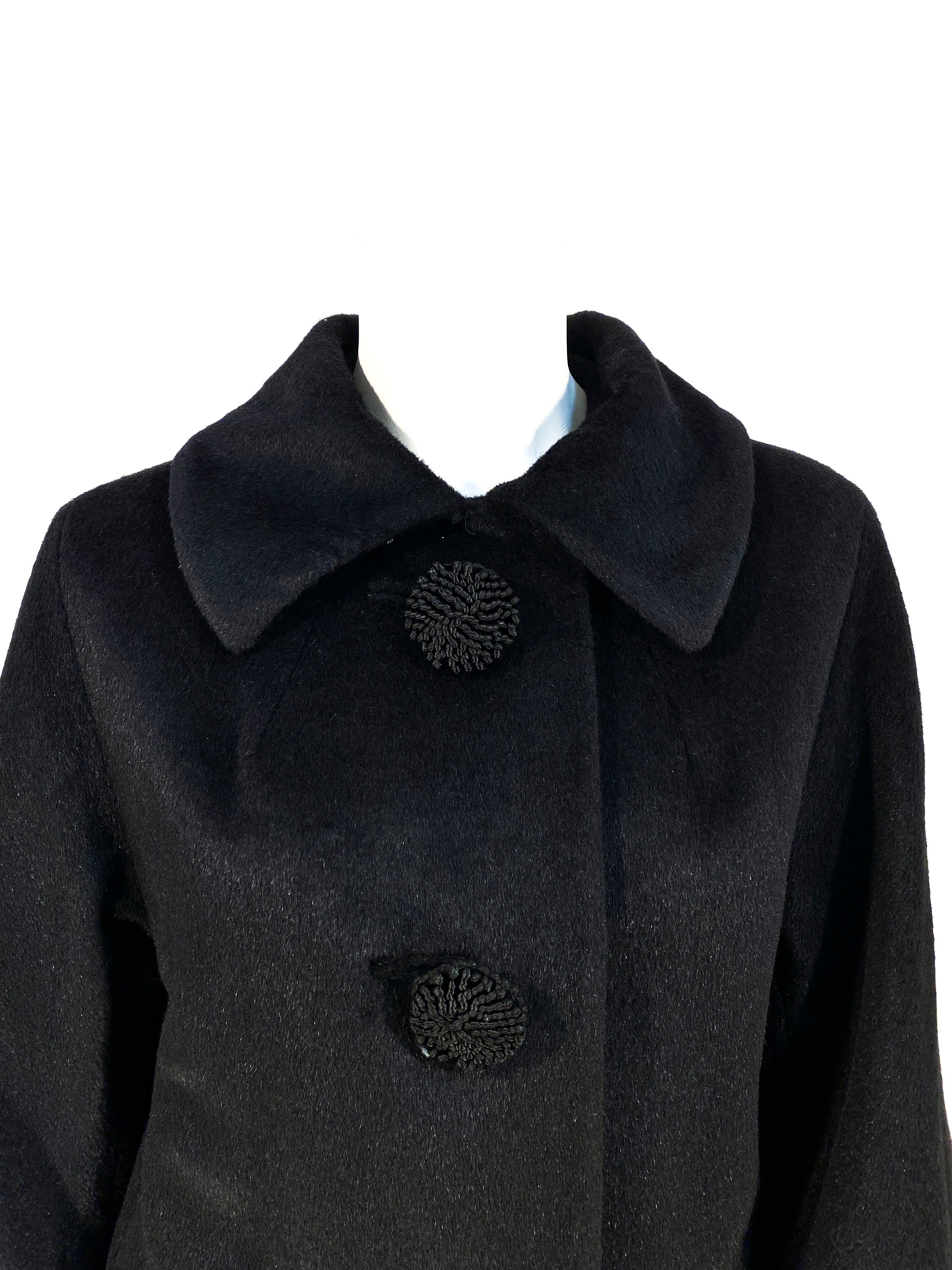 1960s Lilli Ann black cashmere coat with faux decorative soutache buttons hiding the snap closure. The faux button holes are inset, the sleeves are glove length, and the body of the coat is straight cut to the knee. The entire coat is lined with a