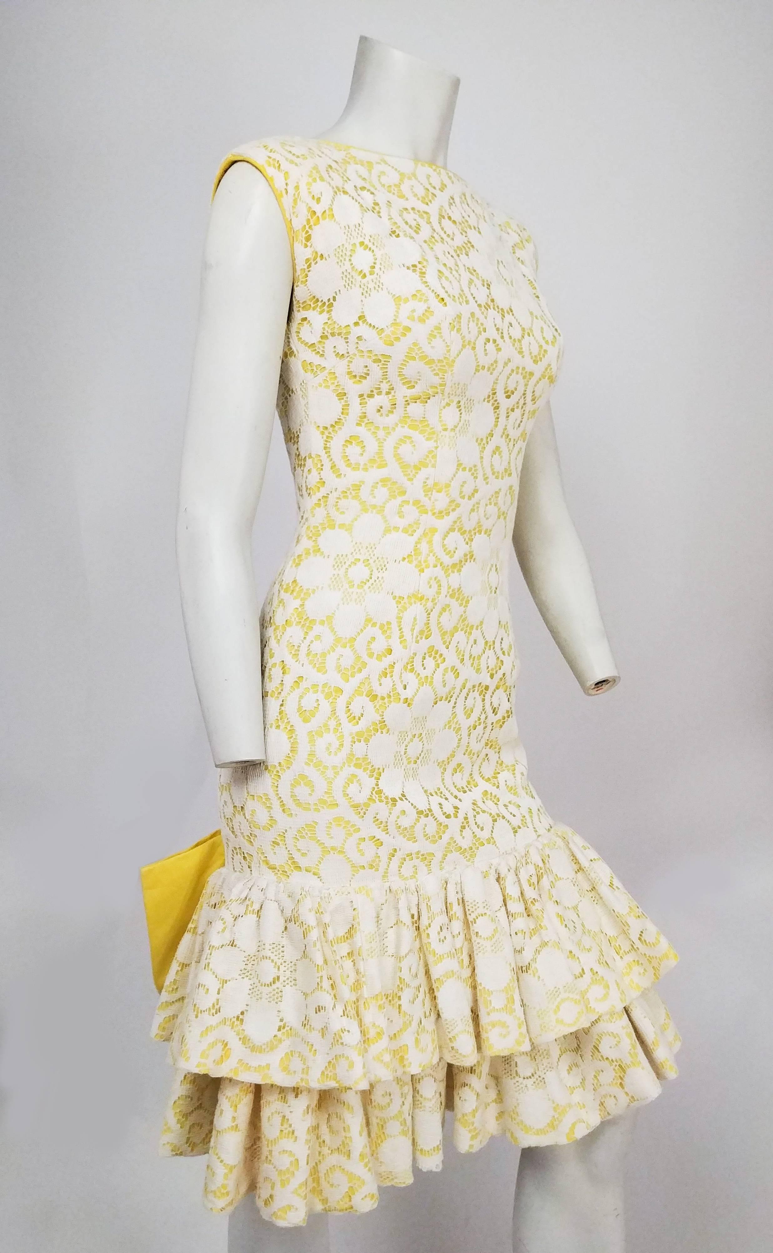 1960er Jahre Lilli Diamond Gelb Drop-waist Ruffle Cocktailkleid w / Lace Overlay. Gelbes Unterteil mit weißem Spitzenüberzug, doppeltem Rüschensaum und großer Schleife am Rücken. Tief ausgeschnittener Rücken. 