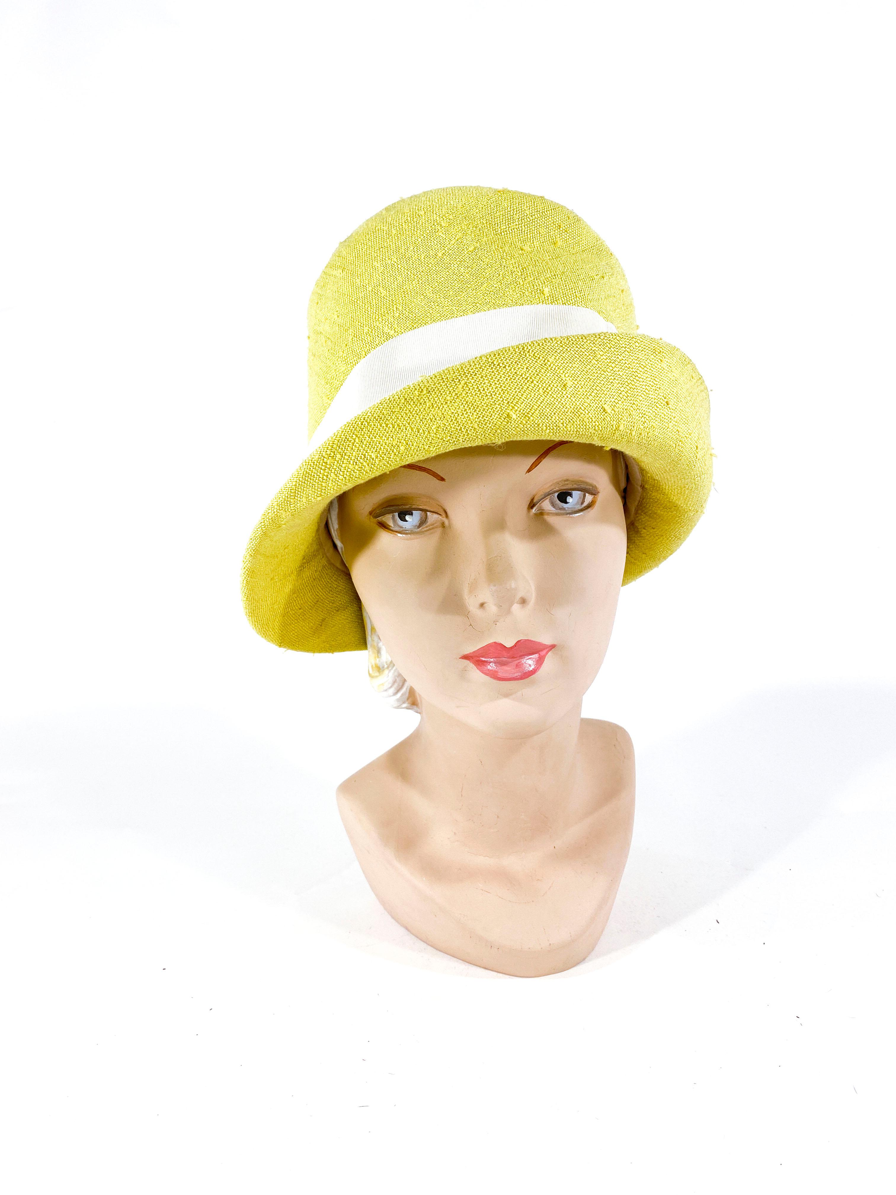 1960s Lilly Dache yellow-green linen hat with a grosgrain designer band and accent button.
