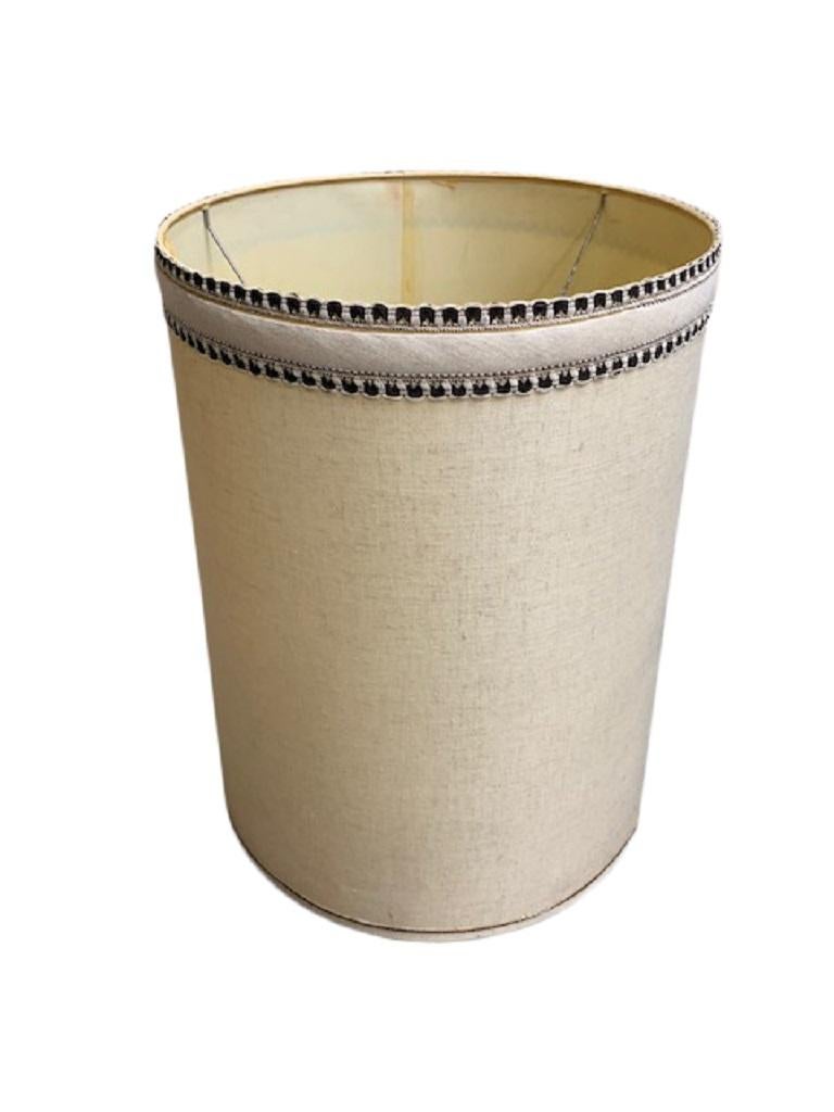 A tall drum-shaped lamp shade, USA, circa 1960. Made of off-white linen with double grosgrain trim at top edge. 

Dimensions (in inches):
16” W x 22.25” H
Shade holder drop from bottom 12”.




   