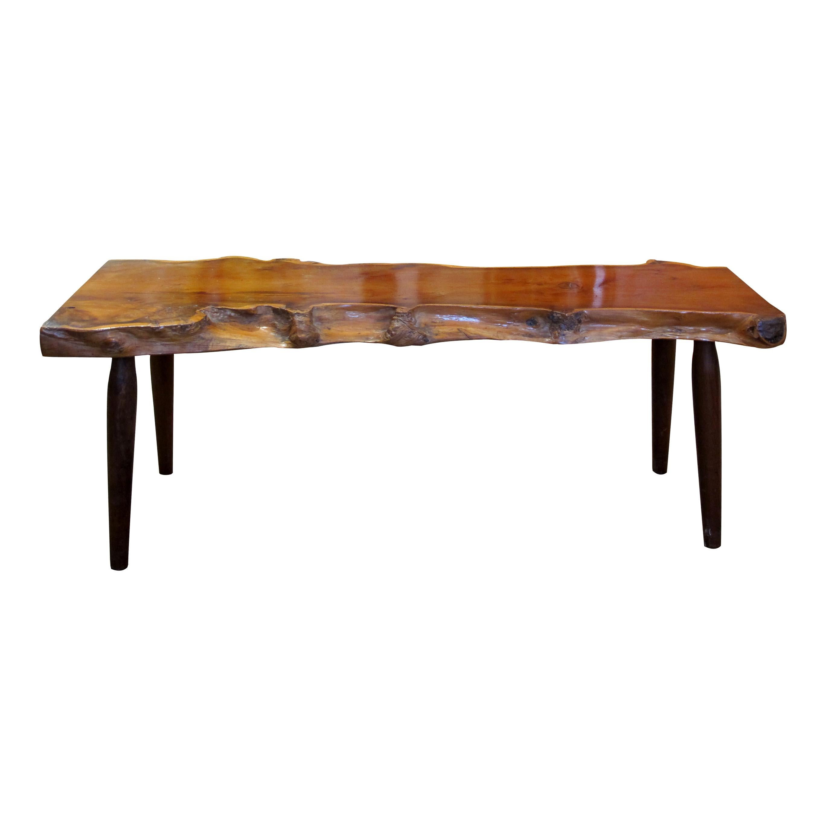 Reminiscent of some of George Nakashima's work this bench is attributed to Reynolds of Ludlow. Crafted with precision and care, the bench boasts a beautiful live edge design, showcasing the natural contours and imperfections and rich hues of the yew